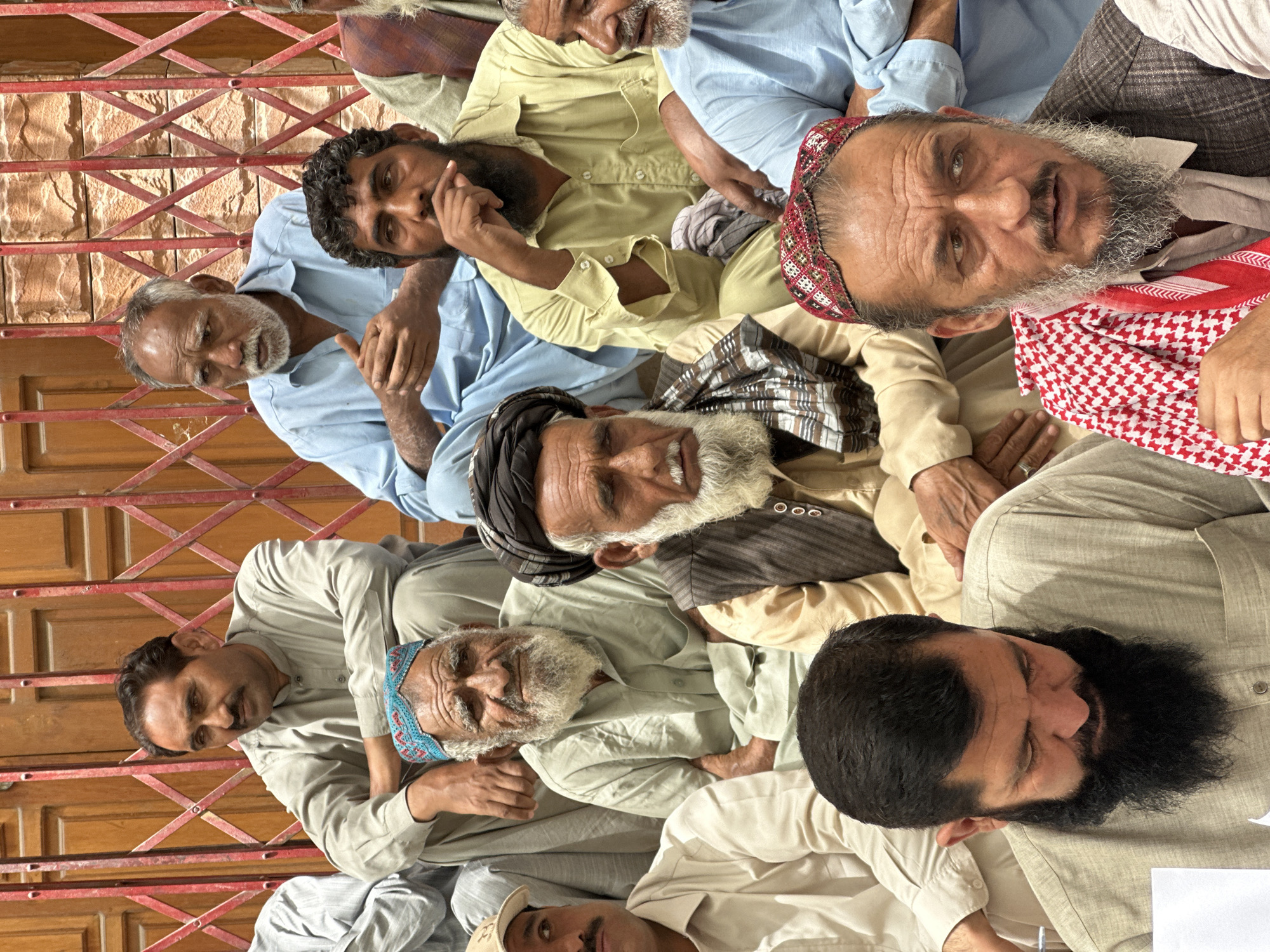 Protest outside gated building in Quetta, signs and speaker present