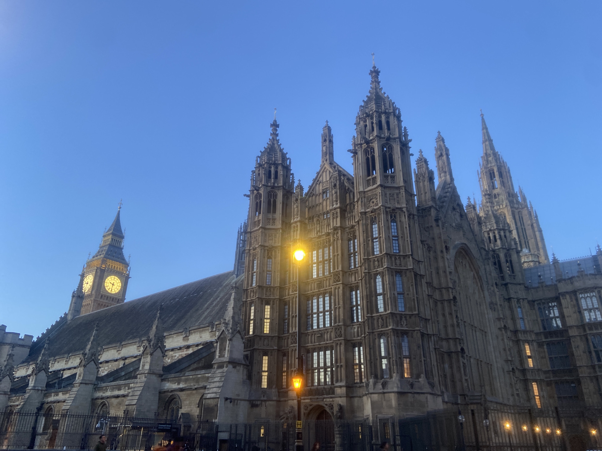Tourist documents Westminster landmarks during London evening twilight