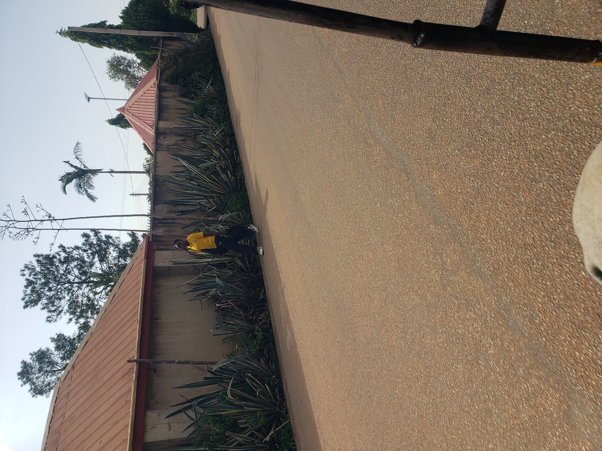Pedestrians walk along paved road in Gura Top, Nigeria