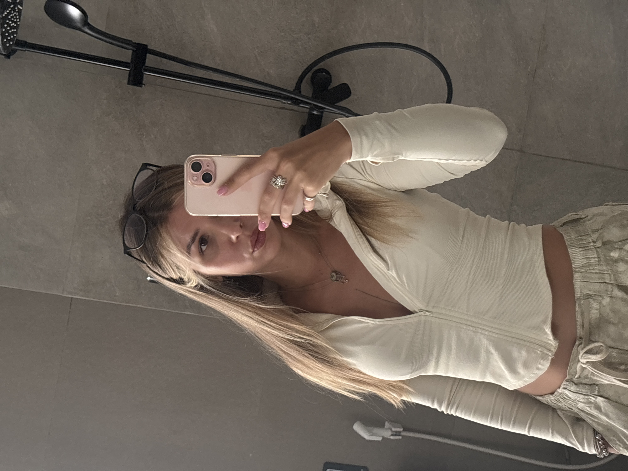 Bathroom mirror selfie, white zip-up and pink iPhone.