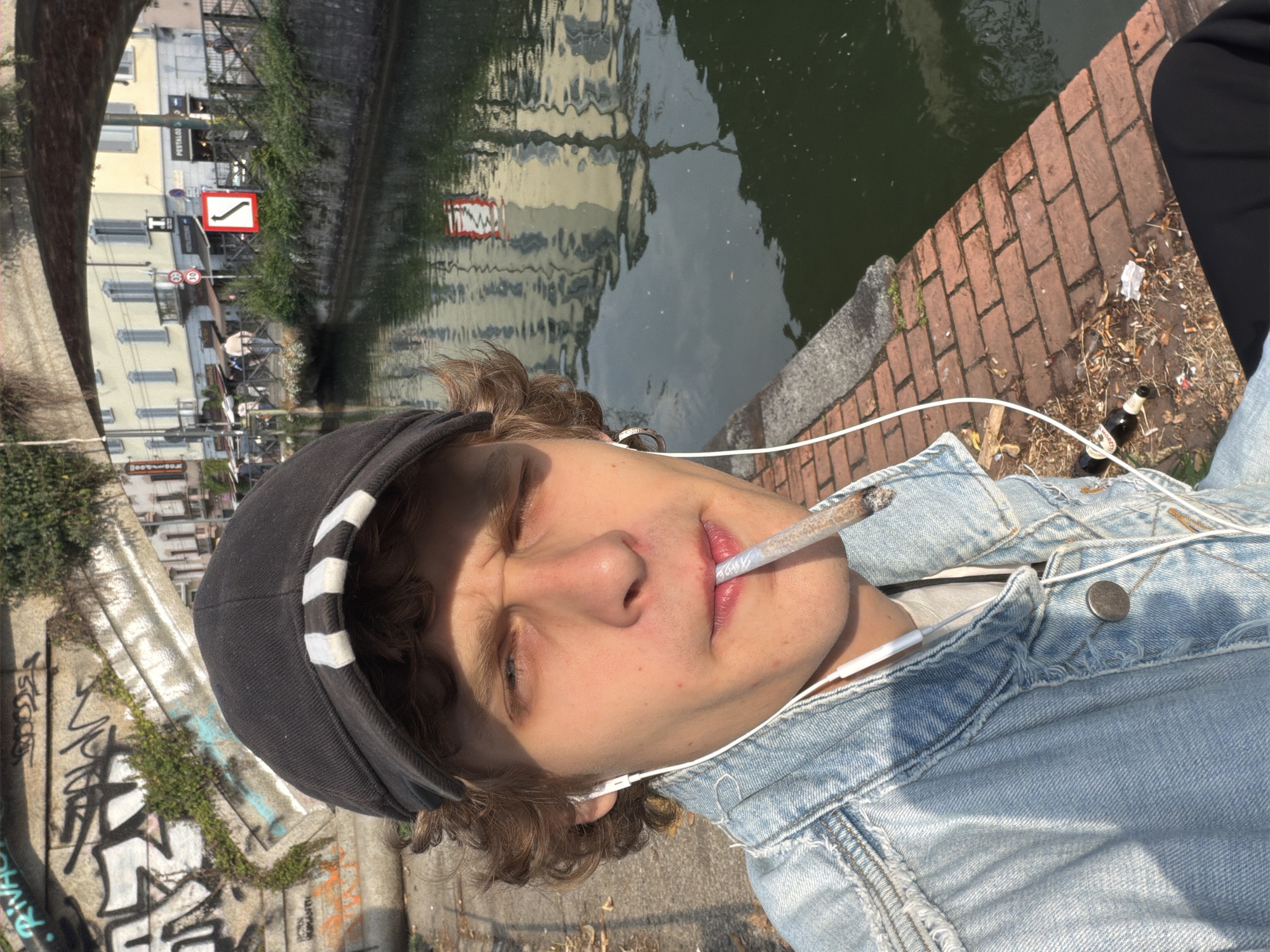 Young person relaxes by canal in Milan's Navigli district