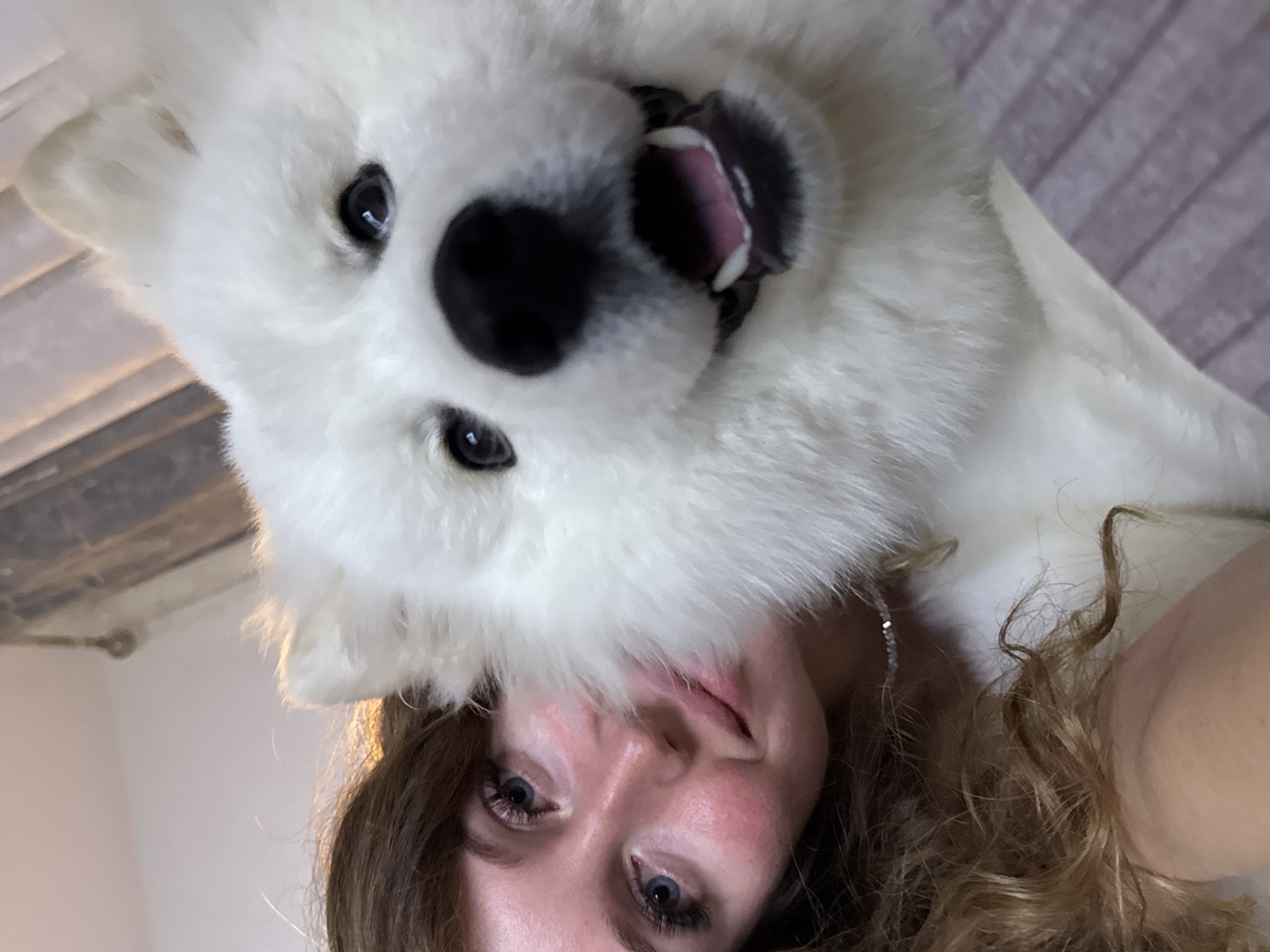Woman photographed with white dog on bed in Chaikovsky