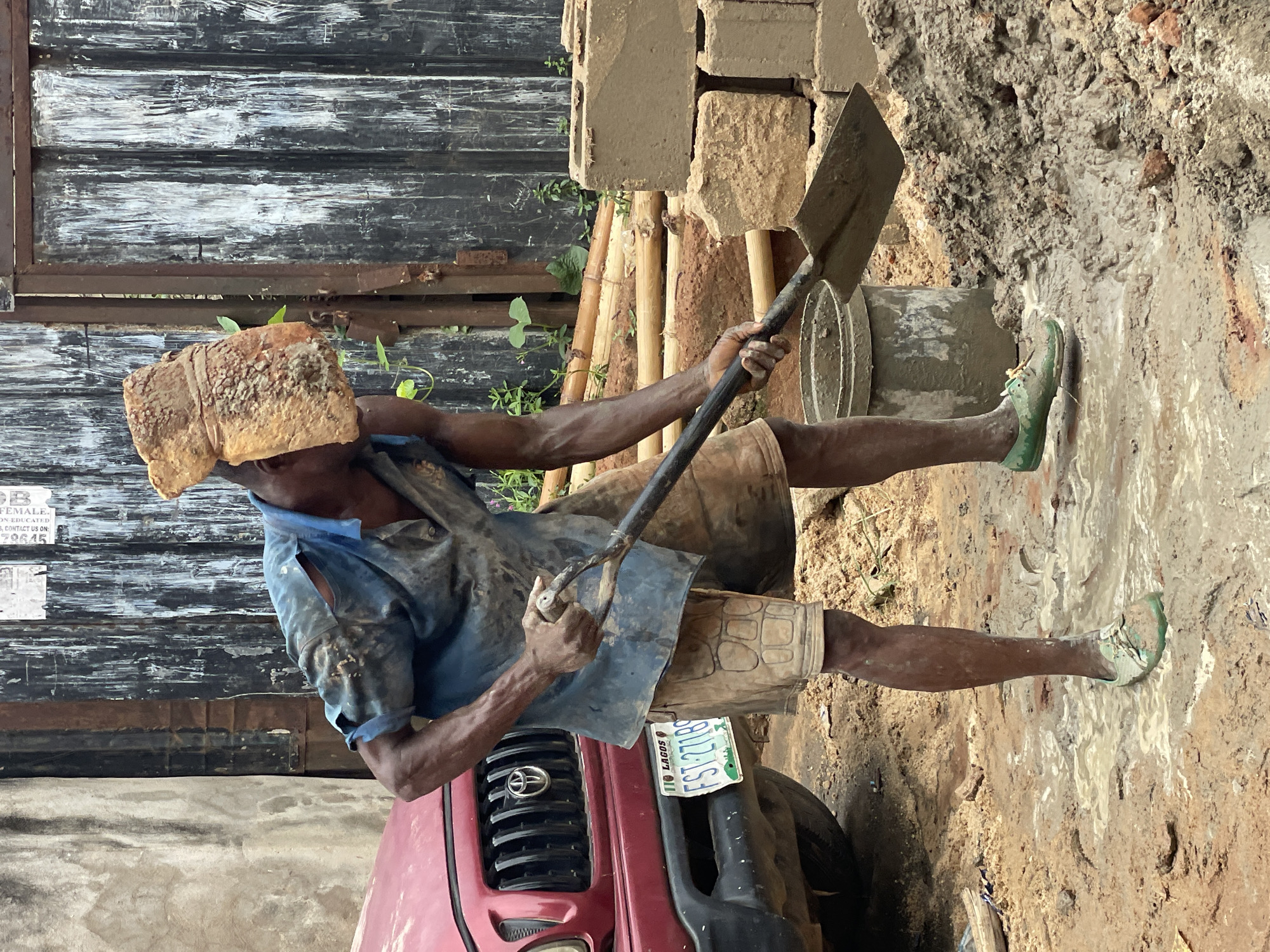 Construction worker carries brick on head in Onitsha