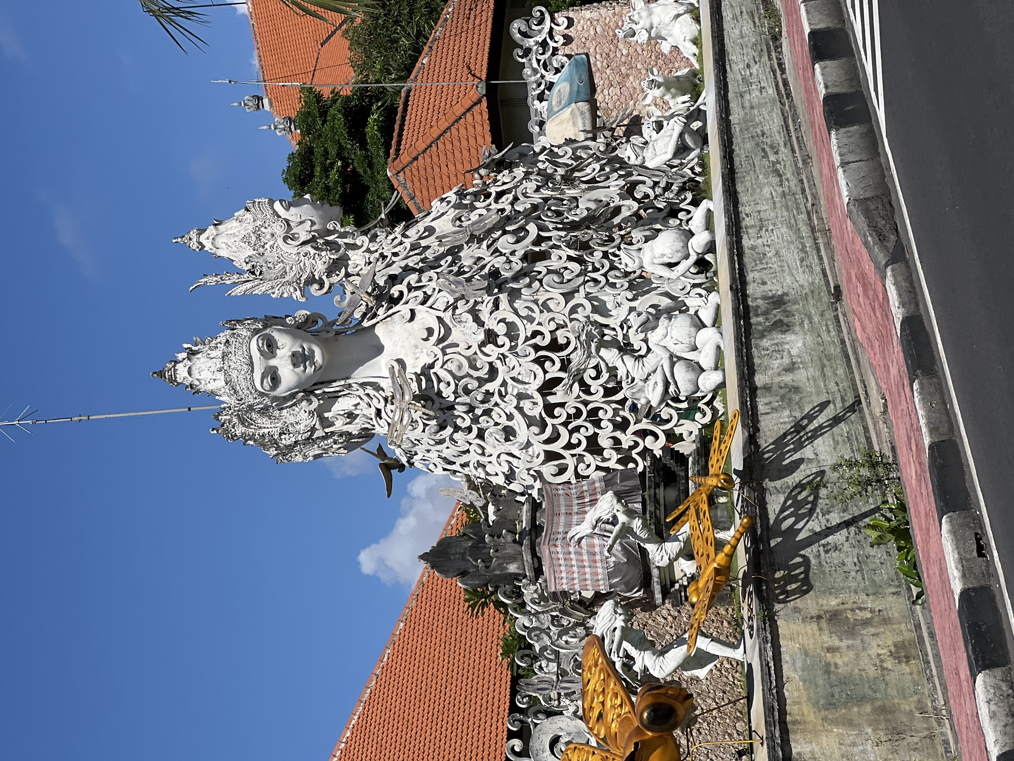 Religious statues and street activity observed in Denpasar area