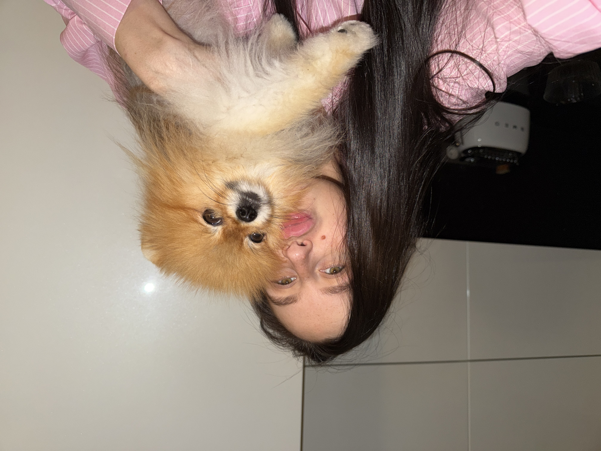 Woman plays with Pomeranian dog in Khimki home