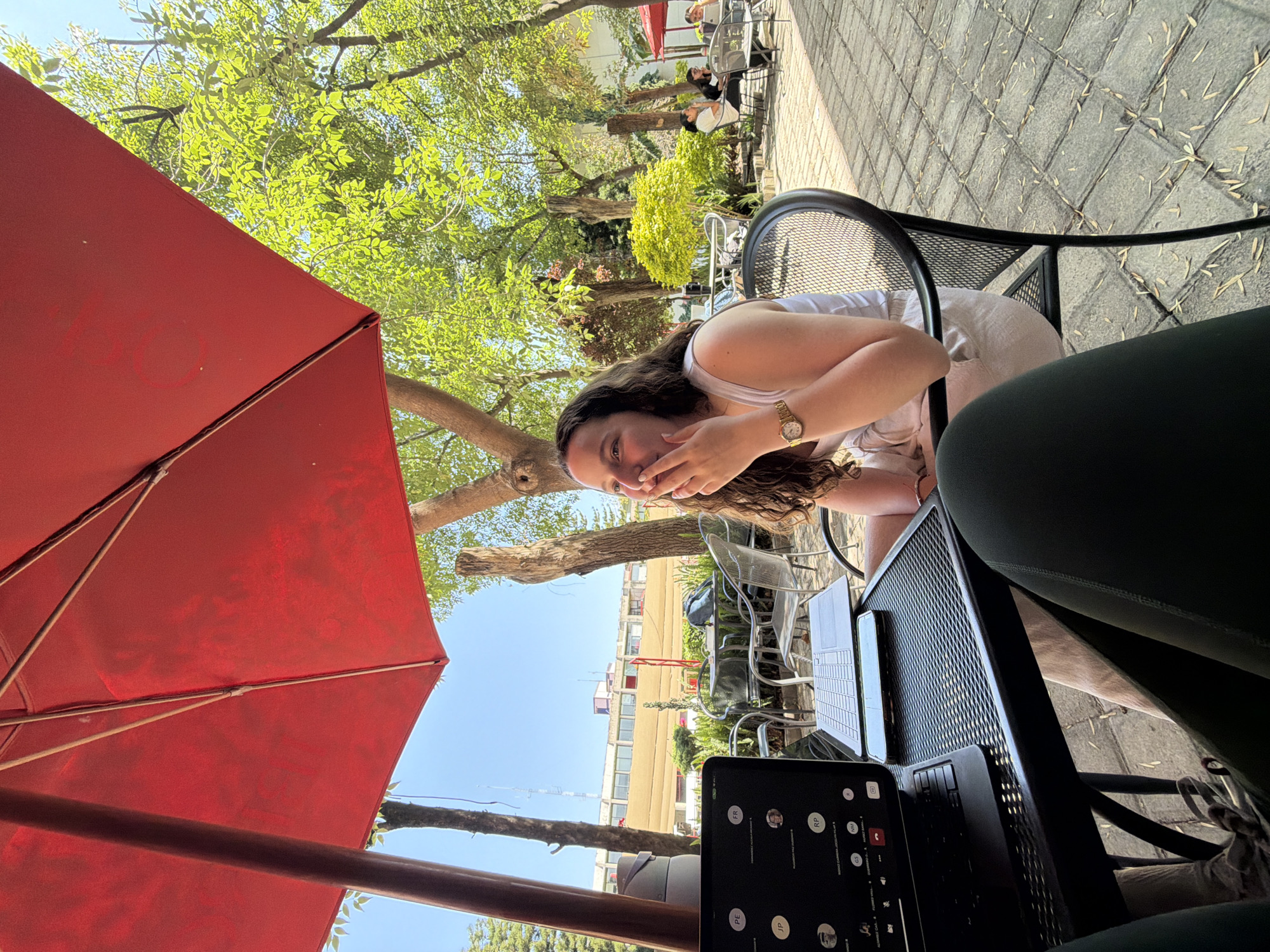 Woman at outdoor café in Tlaxcalancingo under red umbrella