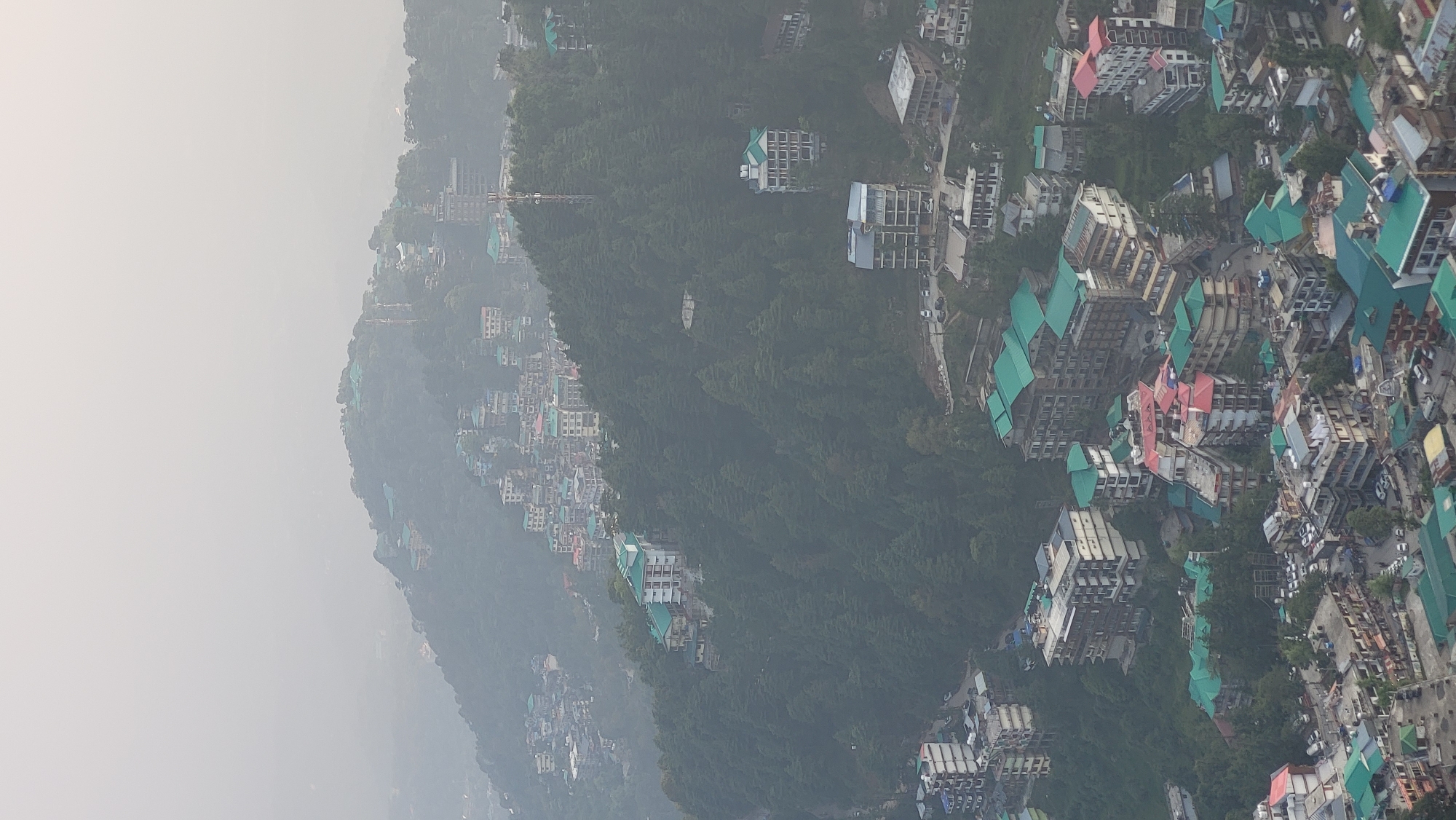 Misty aerial view captured over hillside village of Dharamkot