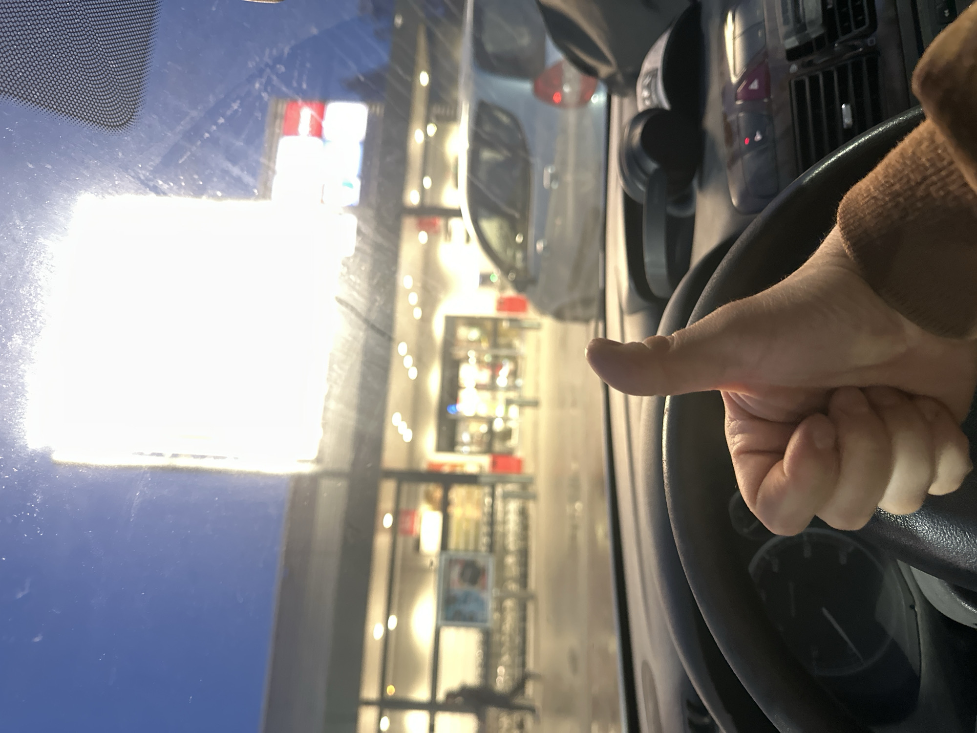 Driver gives thumbs-up gestures in car during rainy night in Sofia