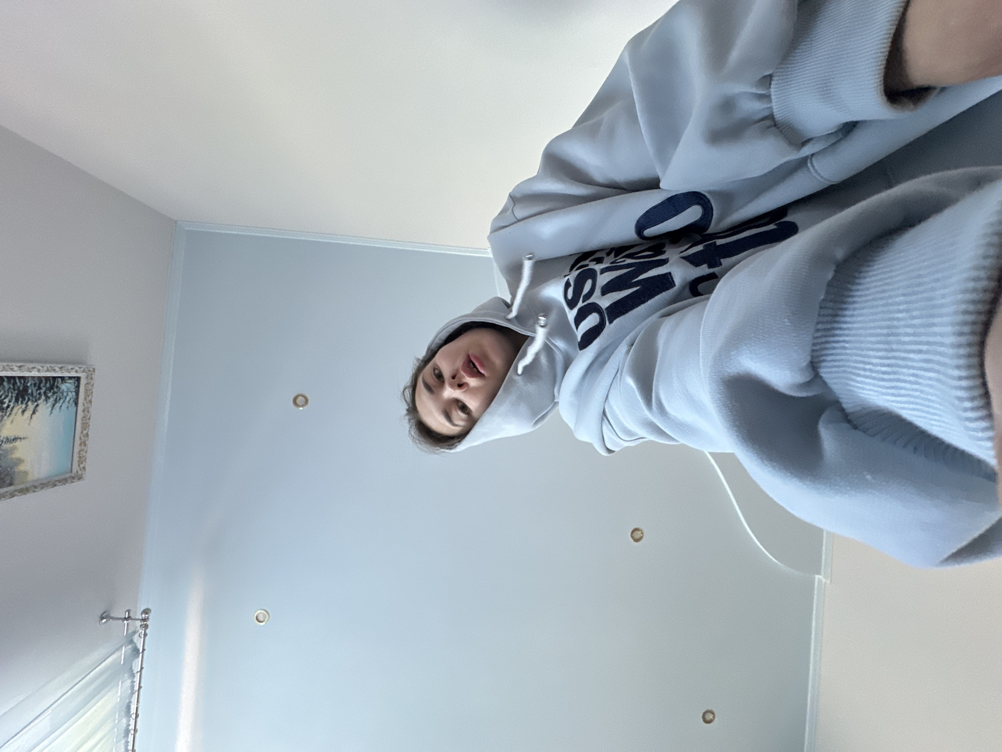 Person in blue hoodie observed indoors in Ilyinsky, Russia
