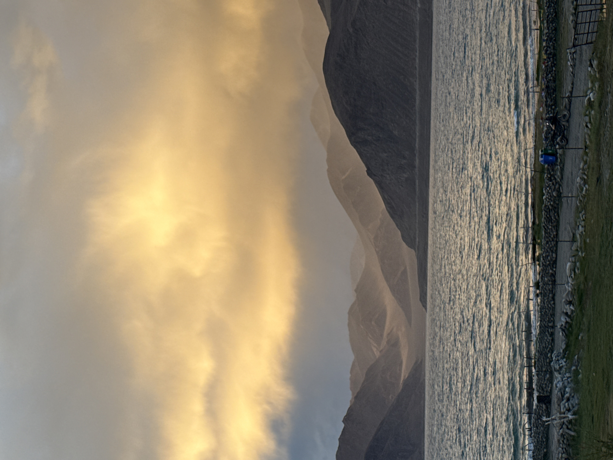 Pangong Tso at sunset, clouds and mountains reflected on still water