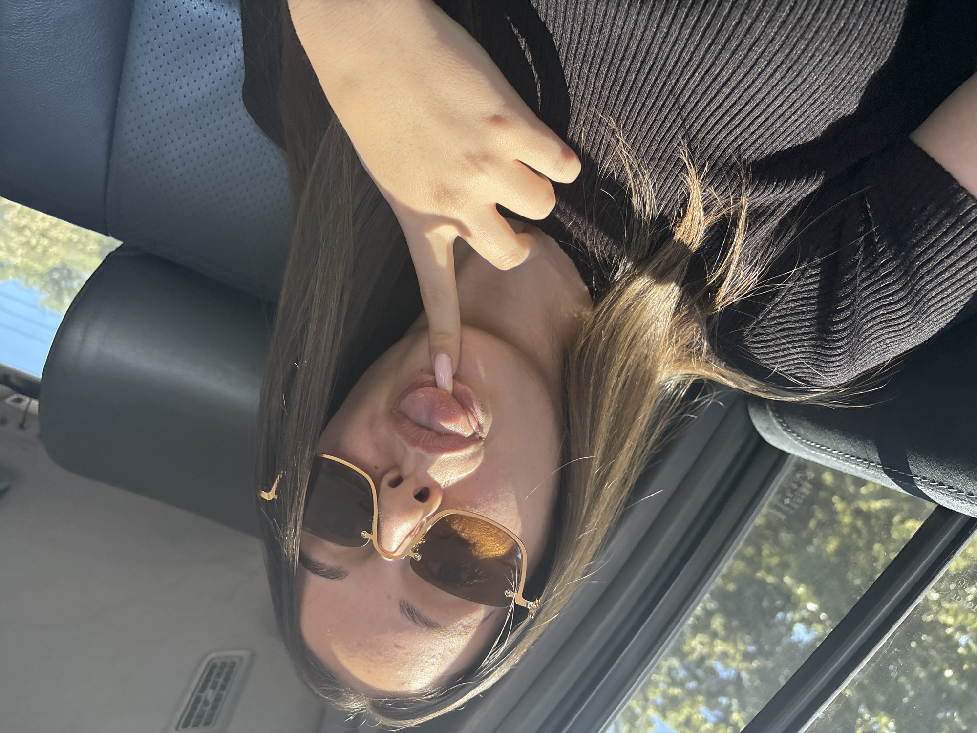 Woman poses playfully in car with decorative manicure in Burgas