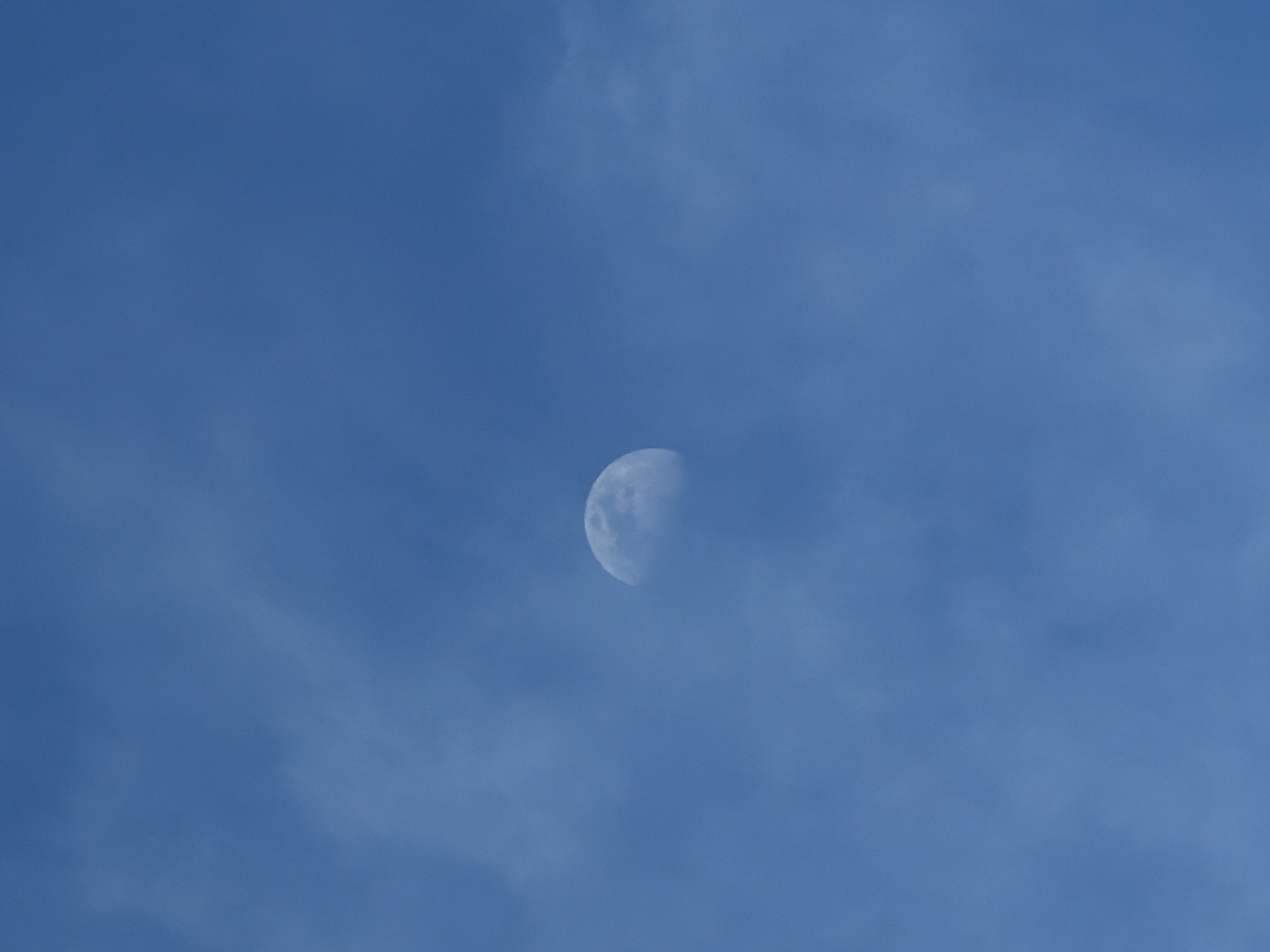 Daytime moon spotted over Velingrad, Bulgaria on clear afternoon