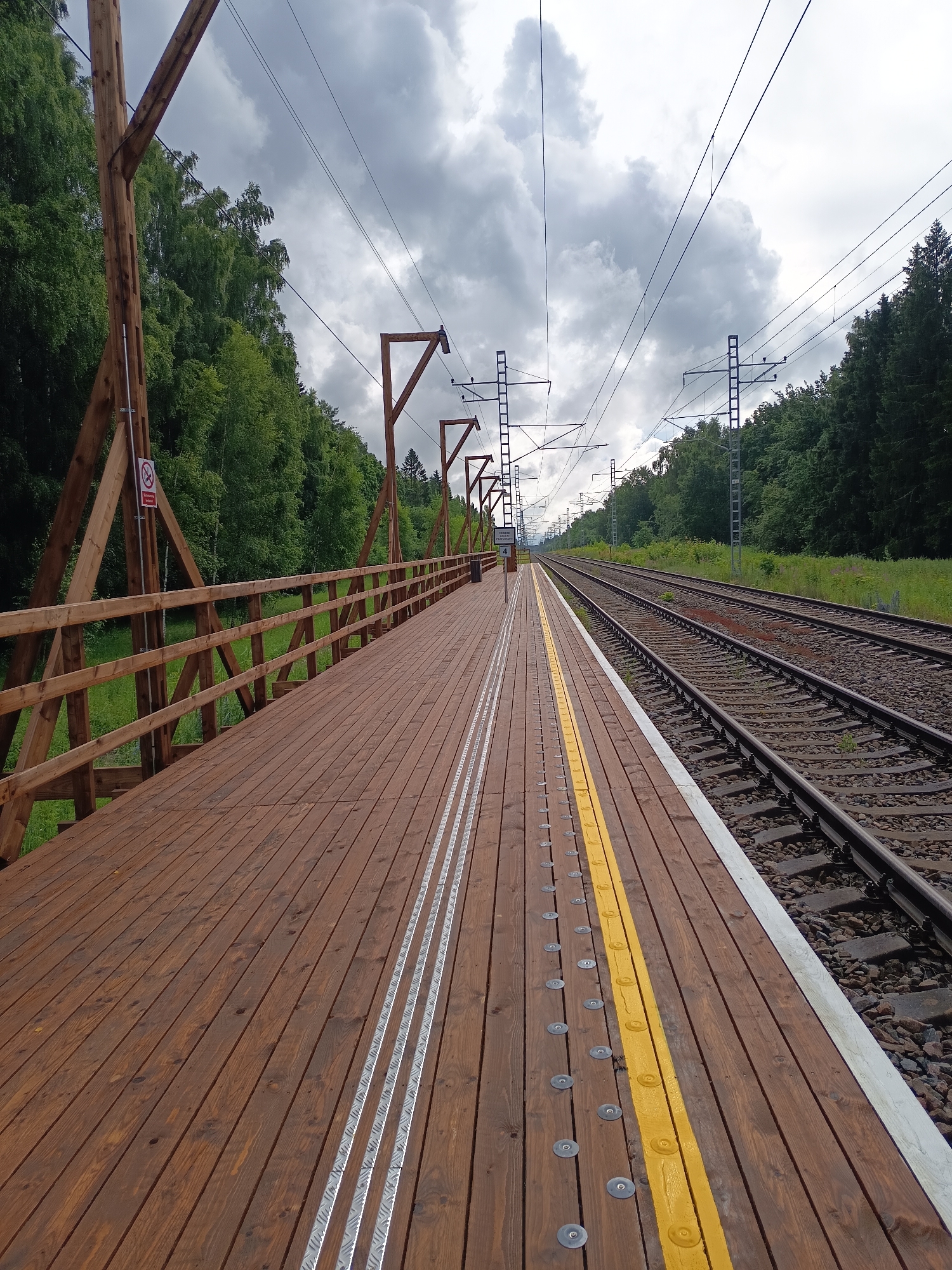 Walking the yellow line at a quiet rural Estonian train platform