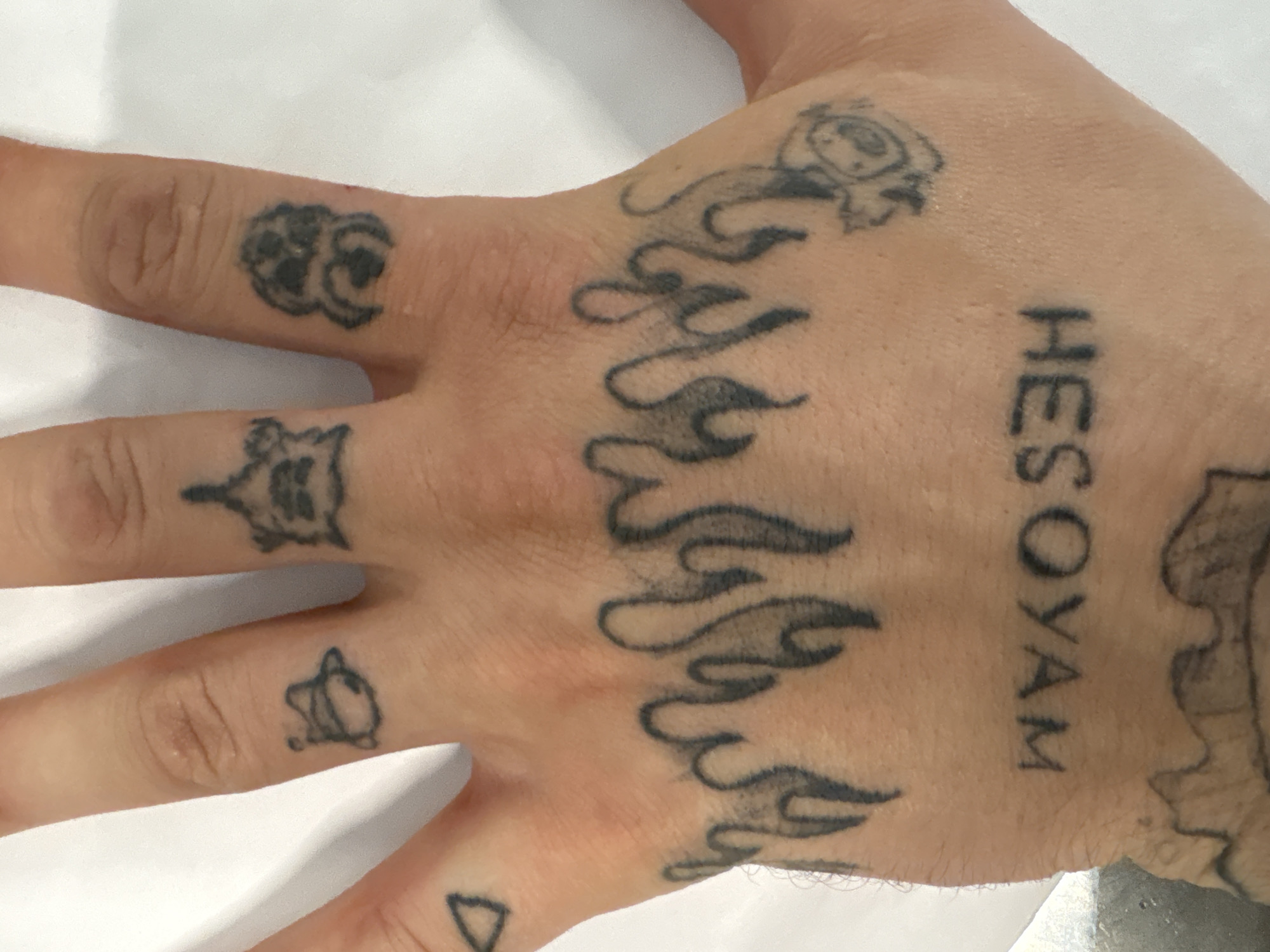 Tattooed hand and wrapped orange sauce portions on a table
