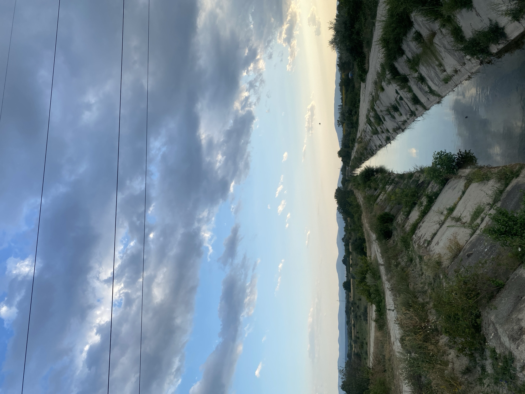 Calm irrigation canal through rural Shumen farmland at golden hour