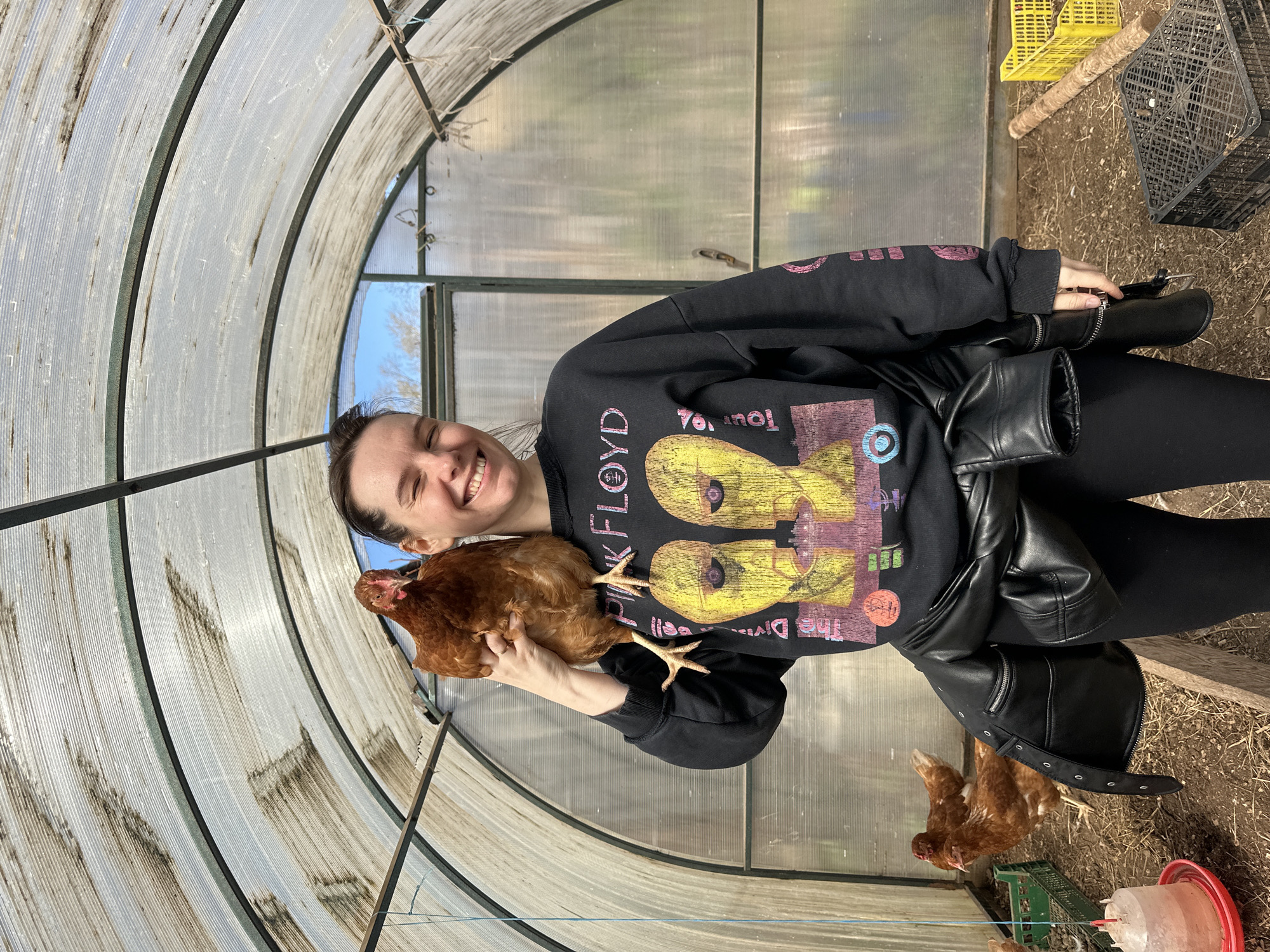 Woman poses with chicken in greenhouse structure in Альняш