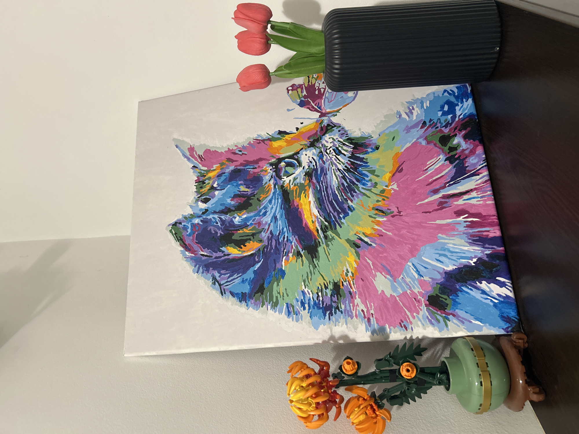 Abstract Animal Painting Displayed with Floral Decorations Against Wall