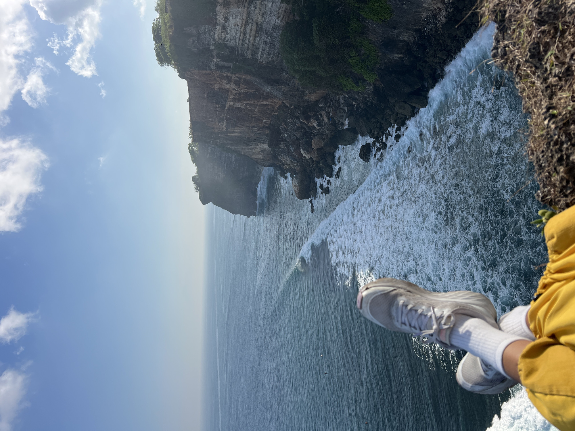 Feet up on a cliff edge in Kuta Selatan