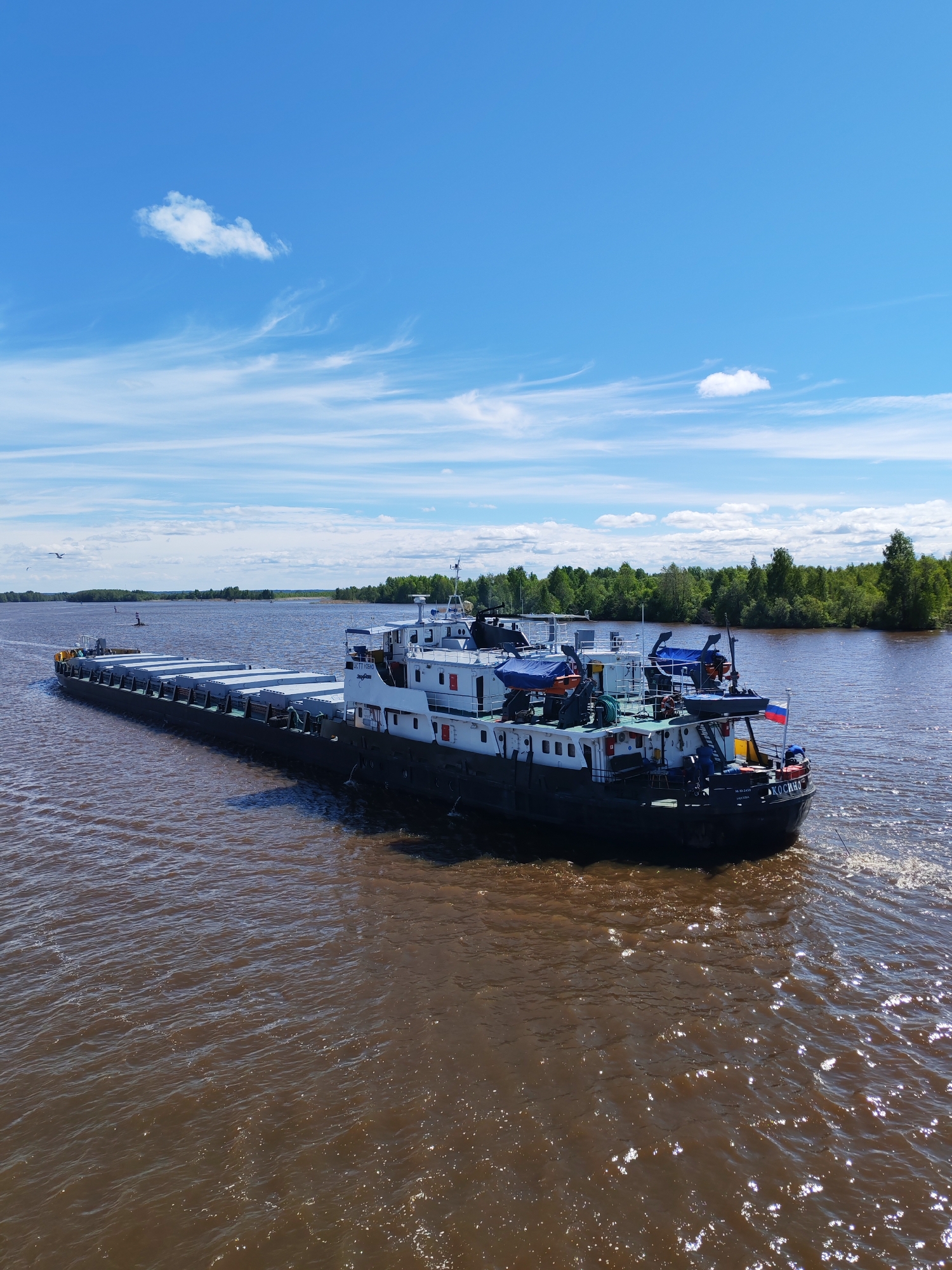 Cargo barges navigate Russian river near Kargulino and Chaika