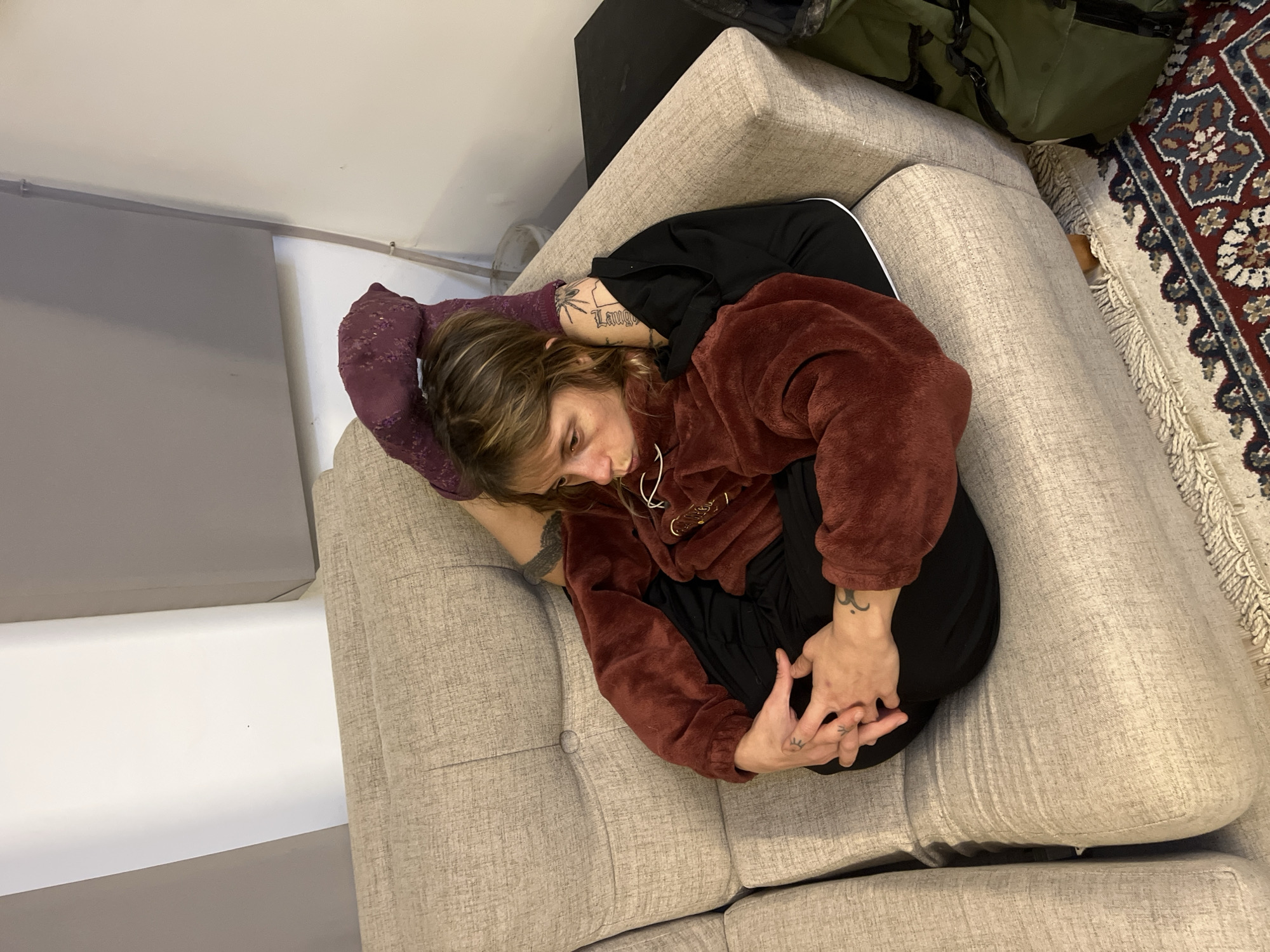 Person rests curled up on couch in La Lucila