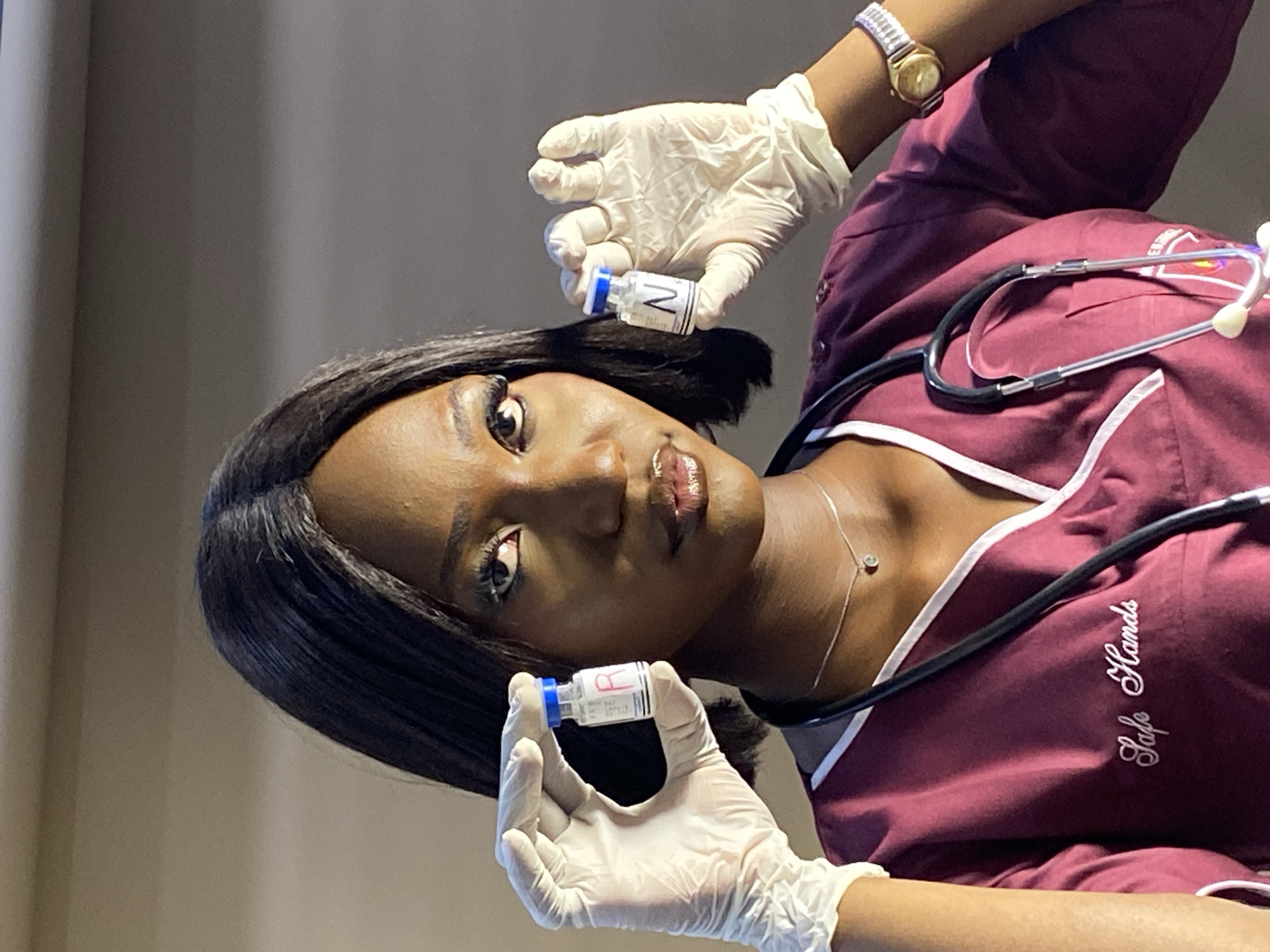 Healthcare worker poses with medication vials in Nigeria studio session