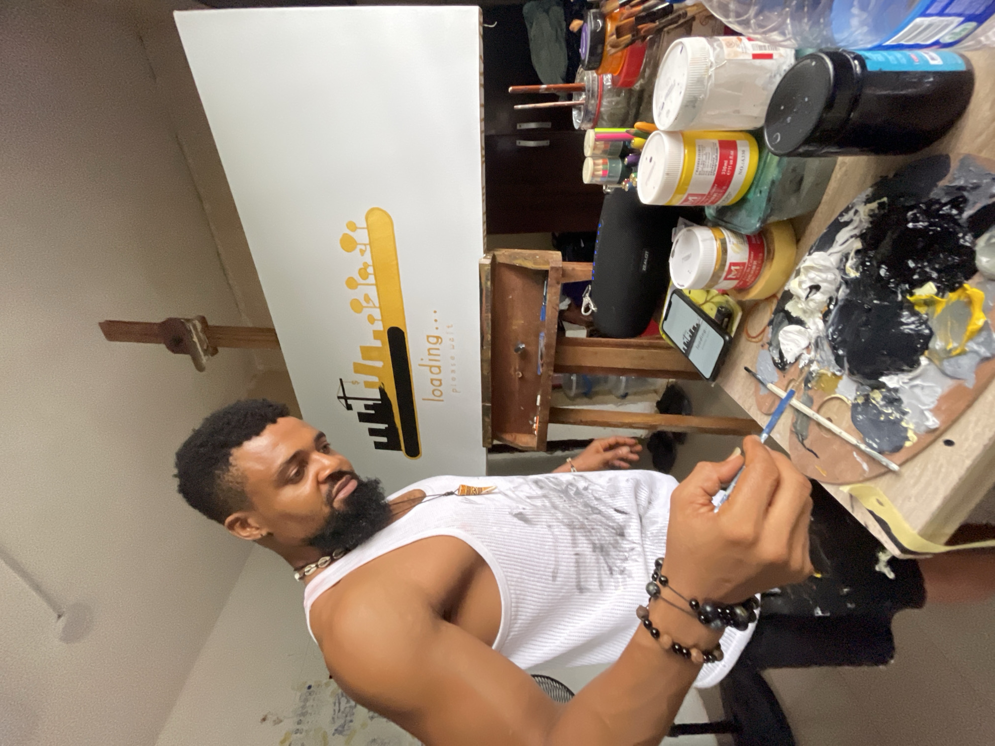 Artist paints on canvas in Ado, Nigeria studio