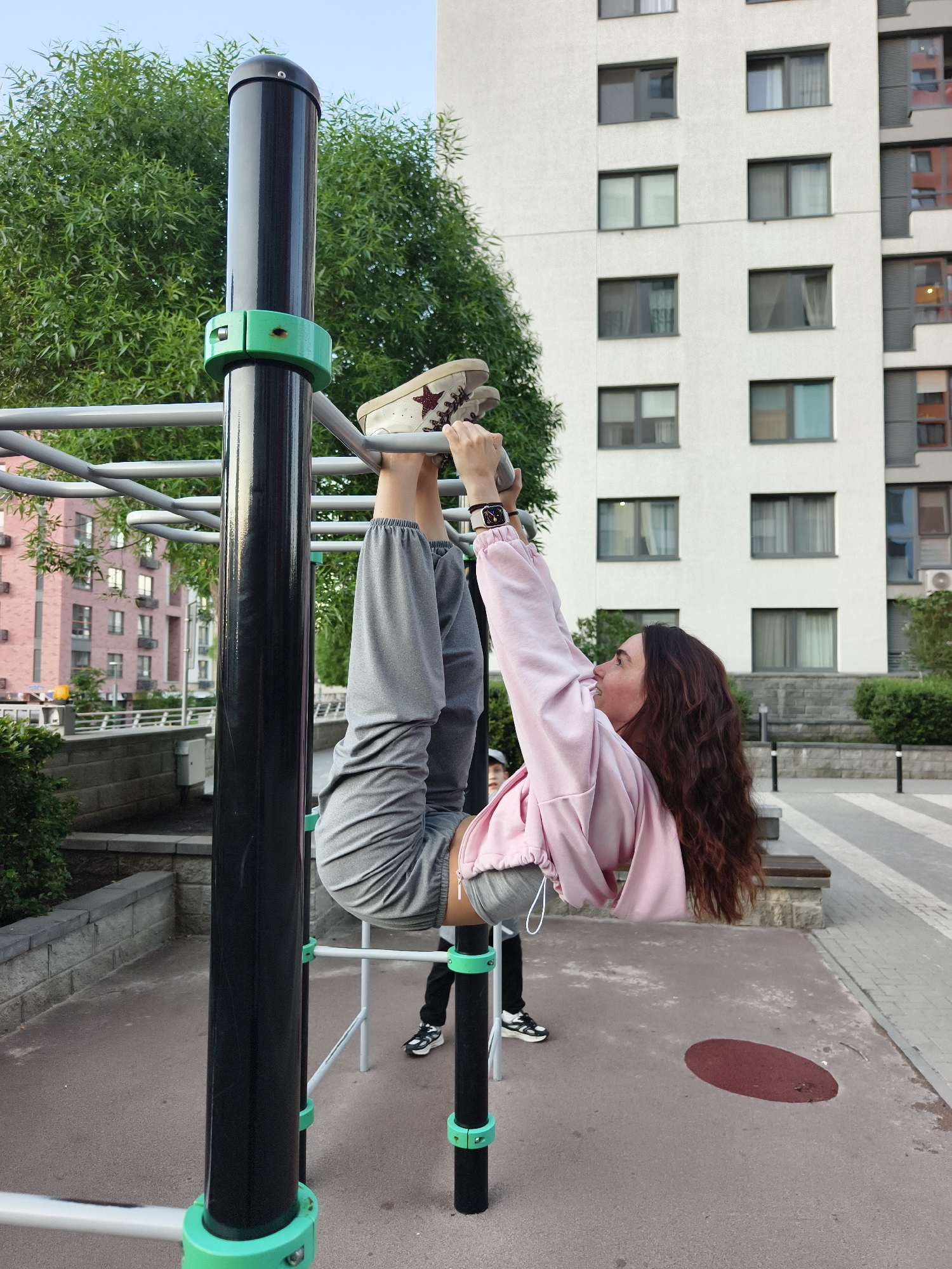 Woman exercises on monkey bars at Tyumen playground
