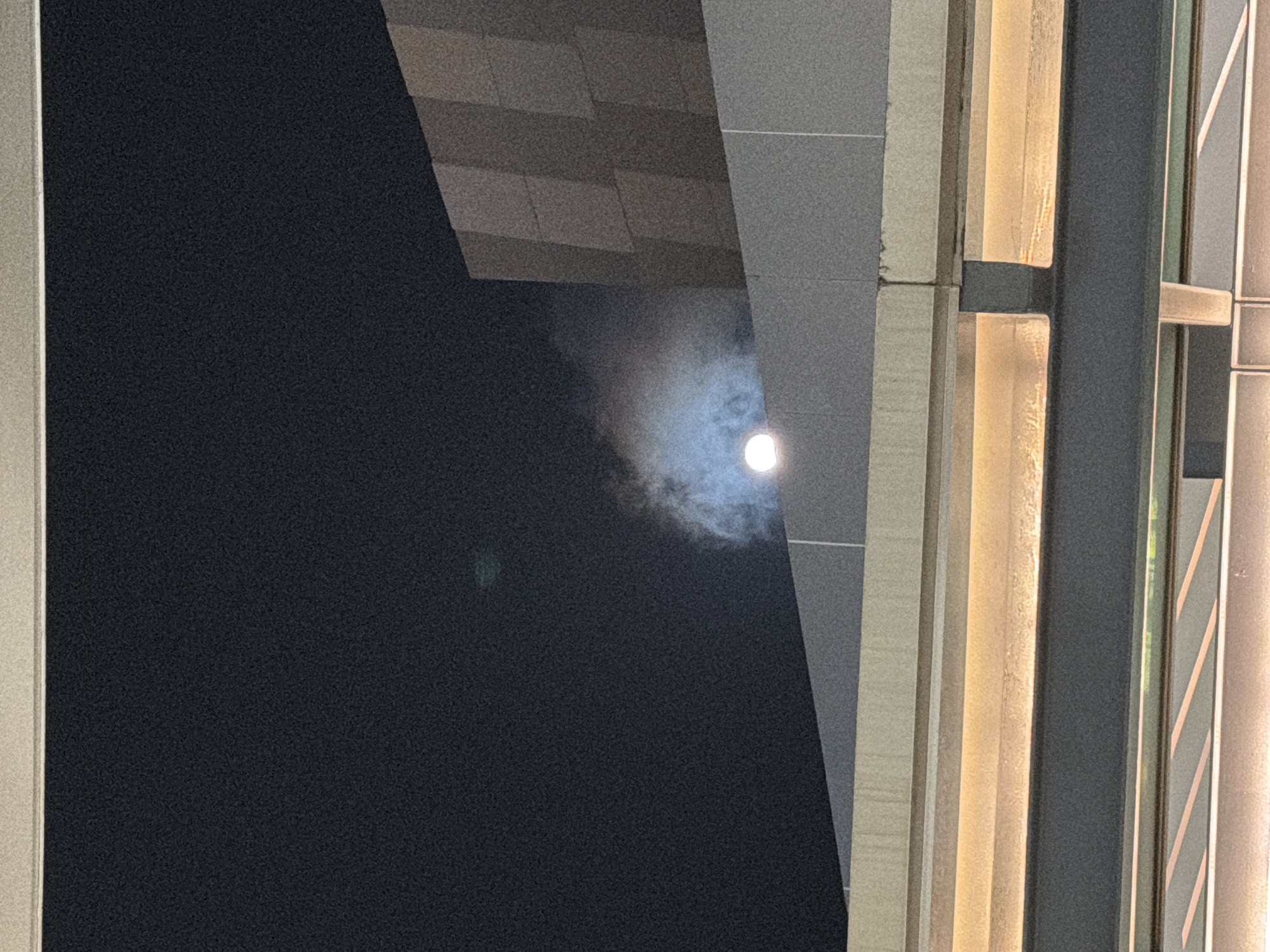 Moon framed by modern architecture in nighttime Cancún