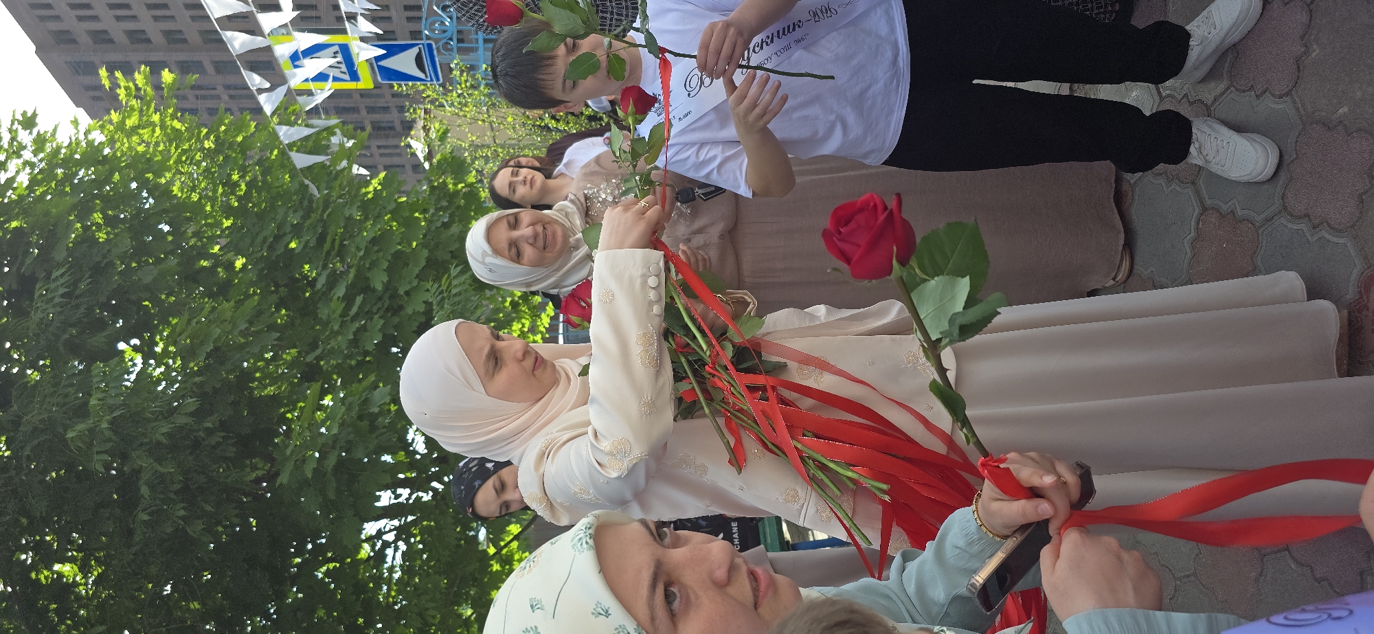 Memorial gathering with roses, balloons observed at educational facility