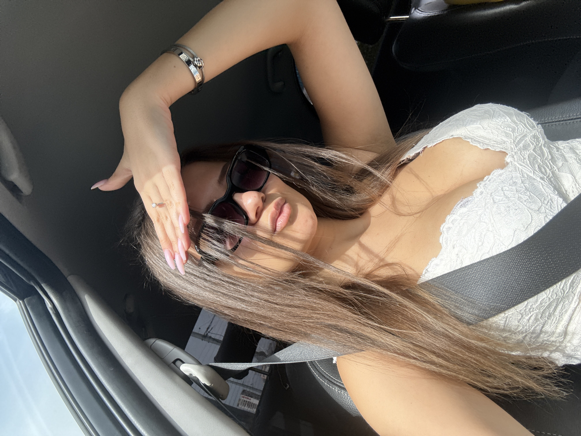 Woman takes selfie in car, shields eyes from sun