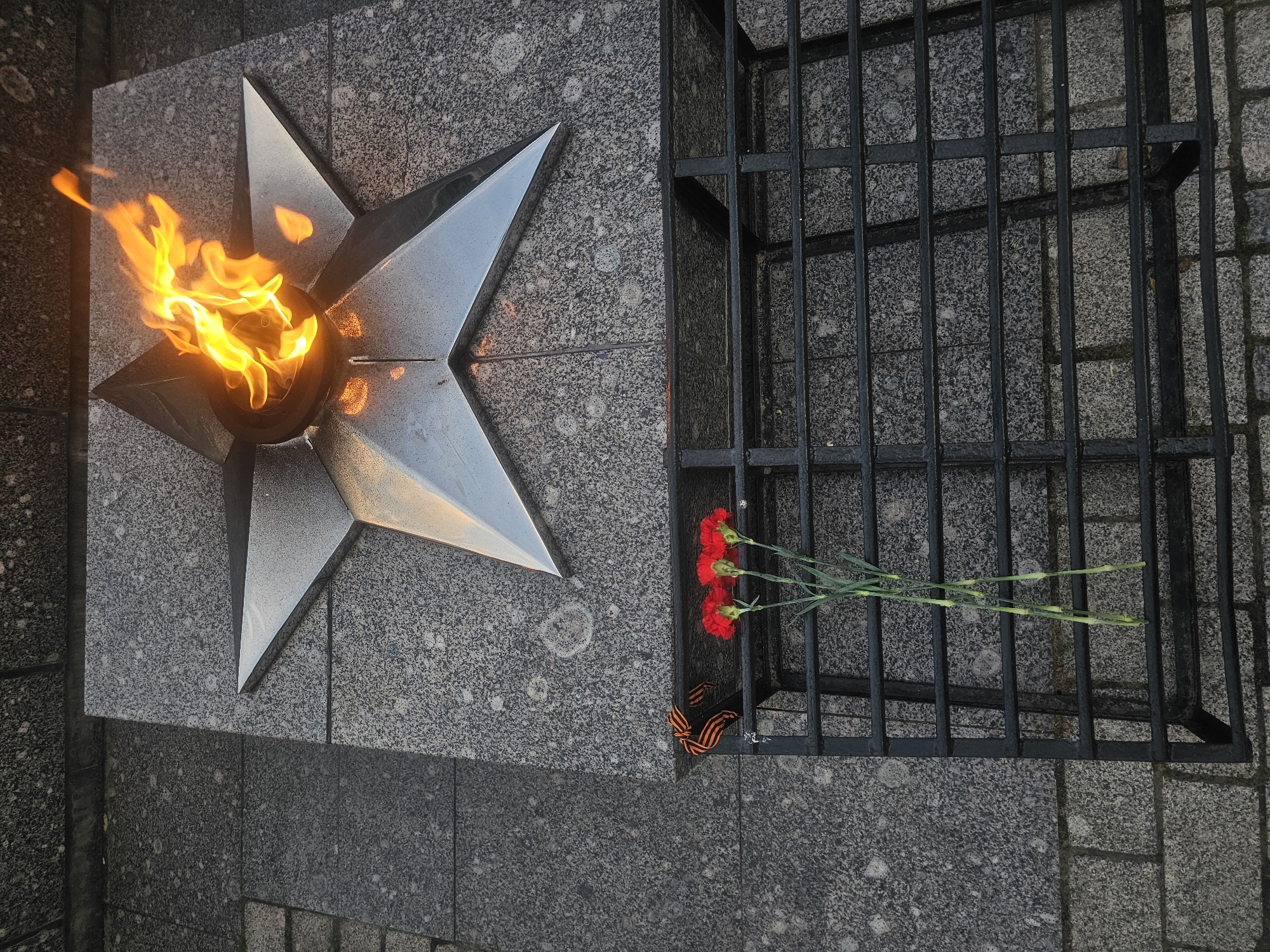 Tosno's war memorial and city streets on a summer evening