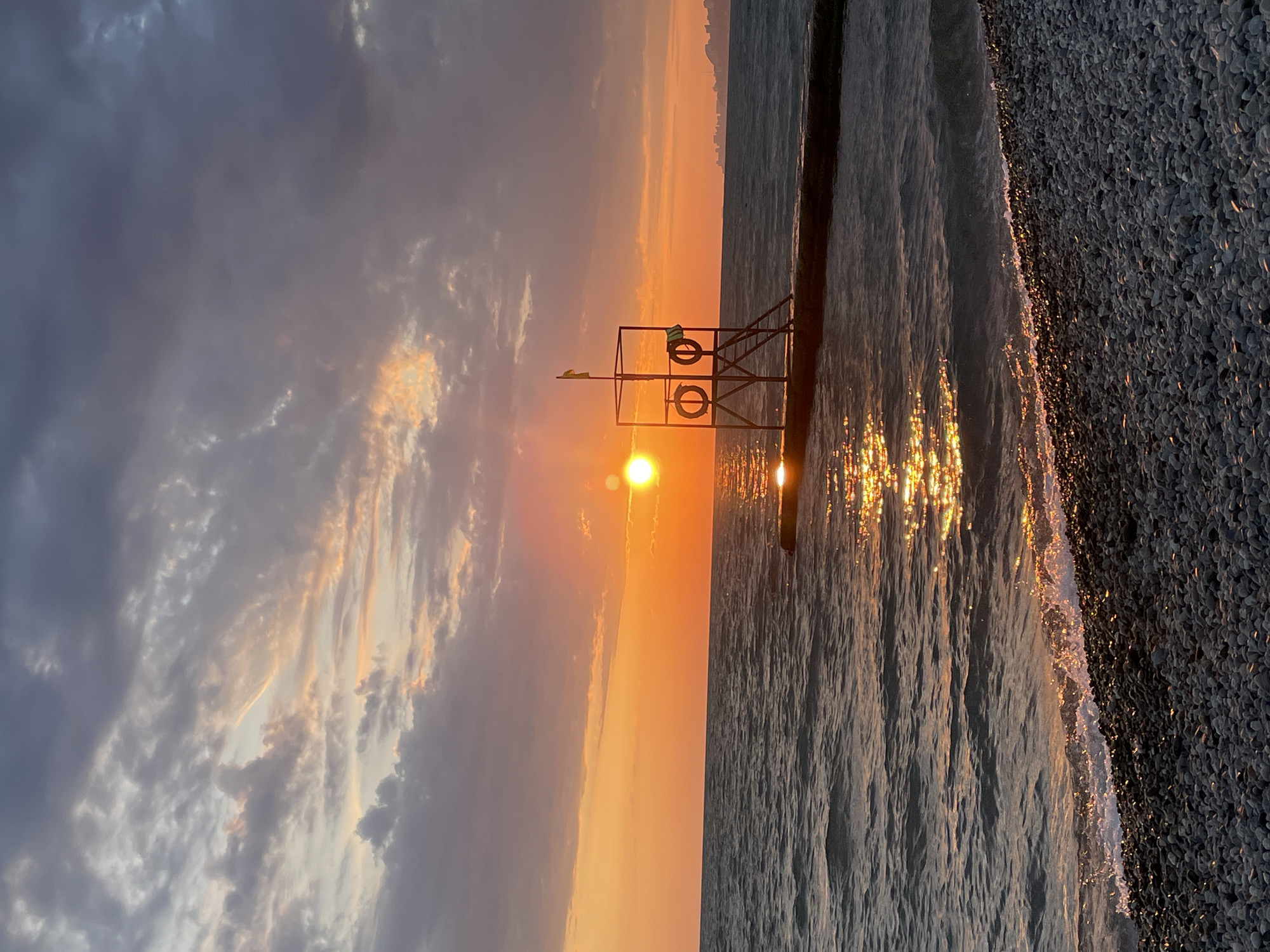Sunset captured on Sochi pebble beach by beachgoer