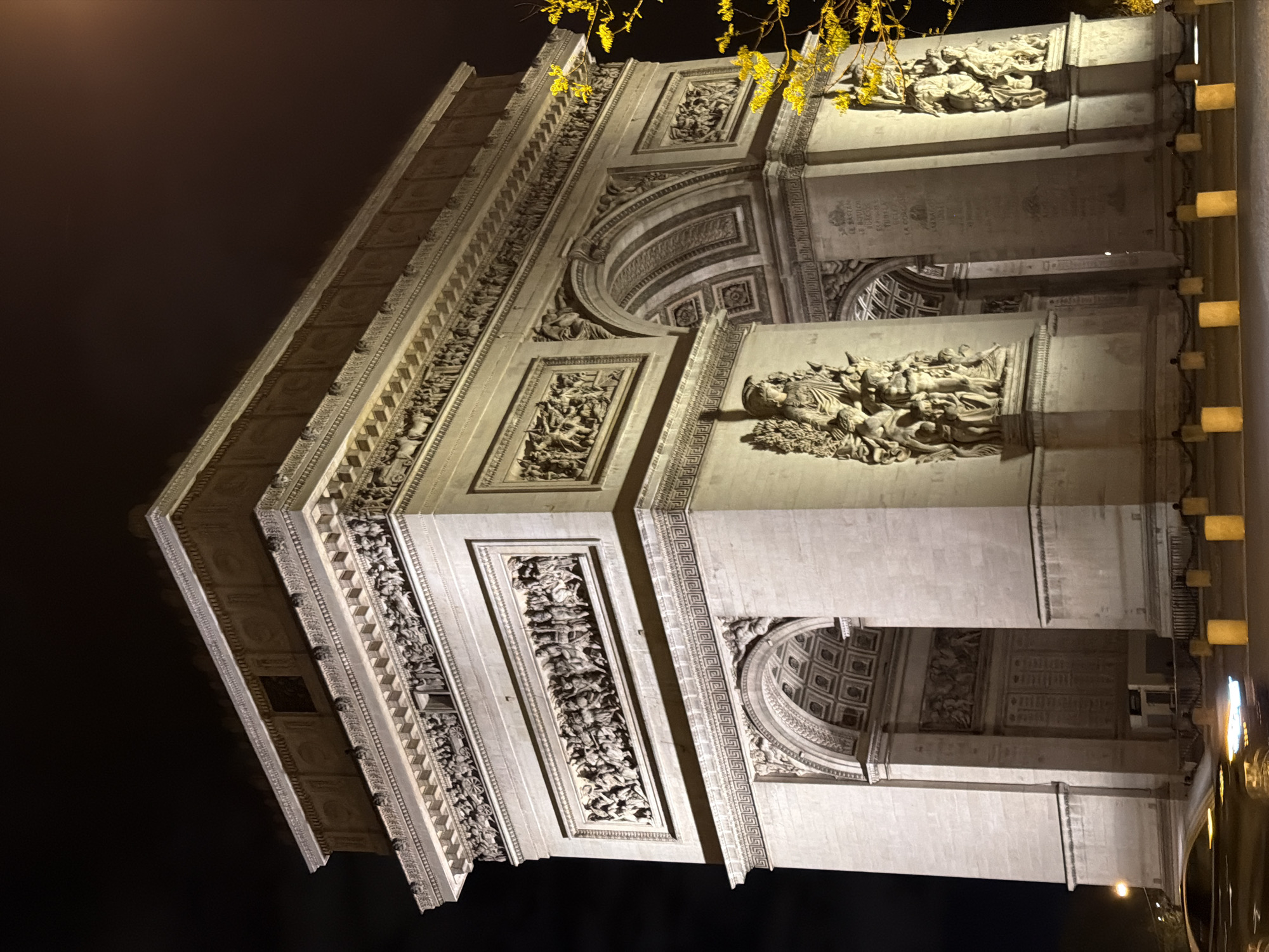 Arc de Triomphe illuminated against dark Paris night sky