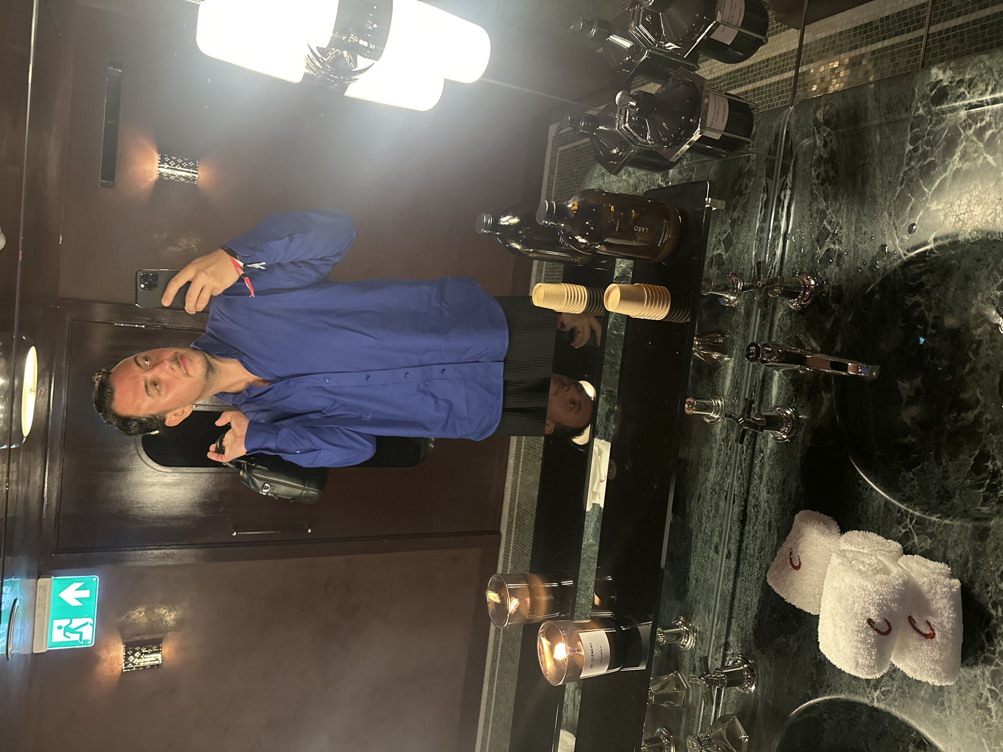 Mirror selfie in a candlelit London bathroom, blue shirt and skirt