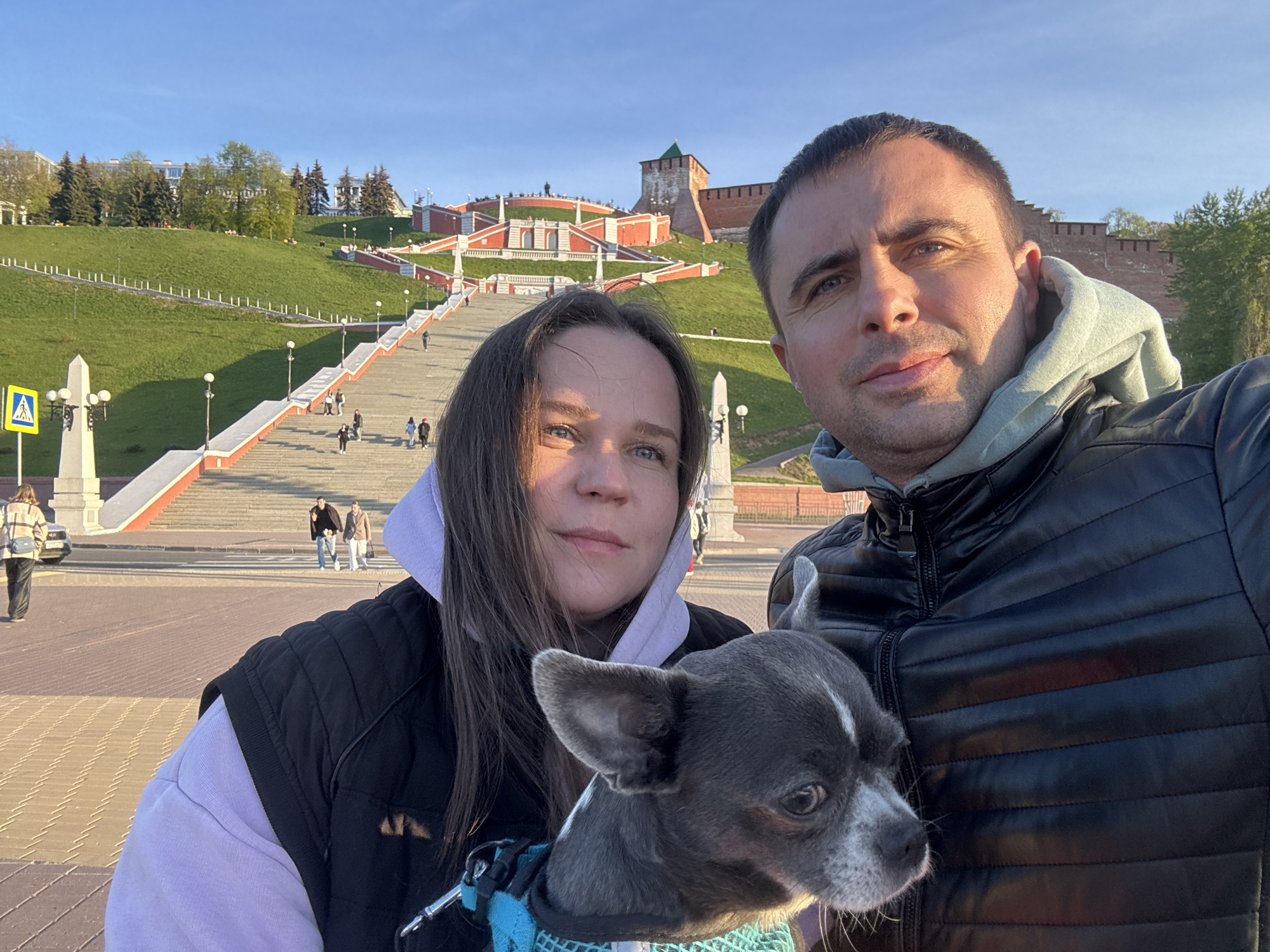 Couple with dog tours Nizhny Novgorod landmarks during spring afternoon