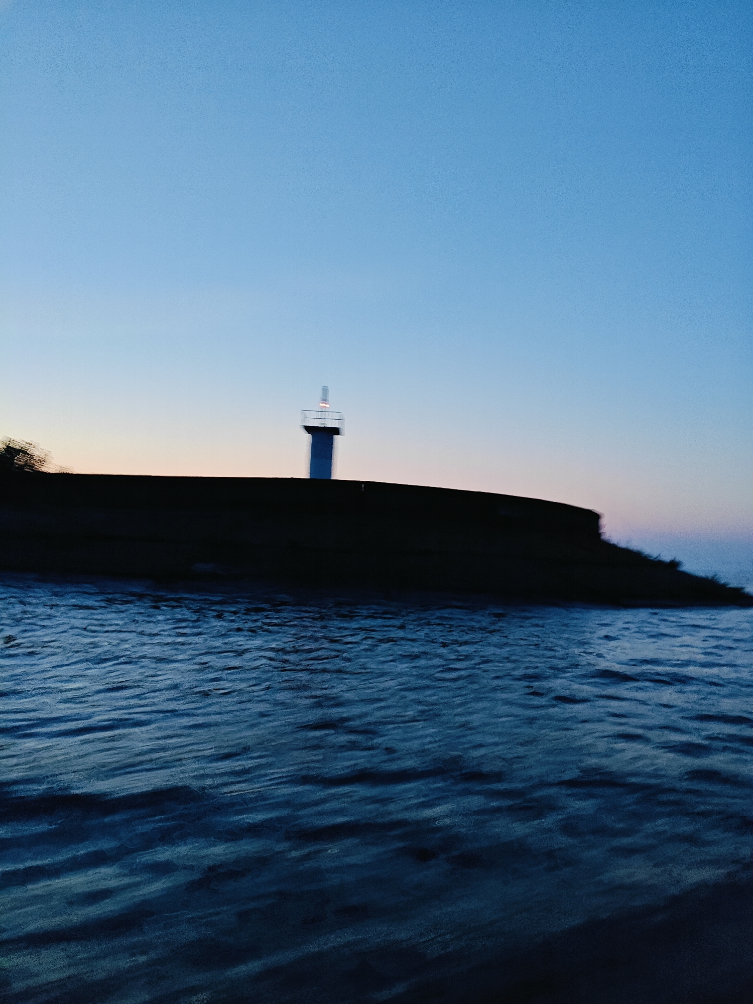 Dusk settles over a Chaikovsky reservoir and its lighthouse