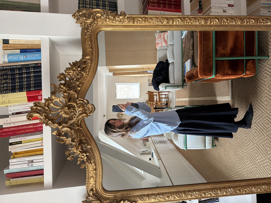 Woman takes mirror selfie in Paris apartment