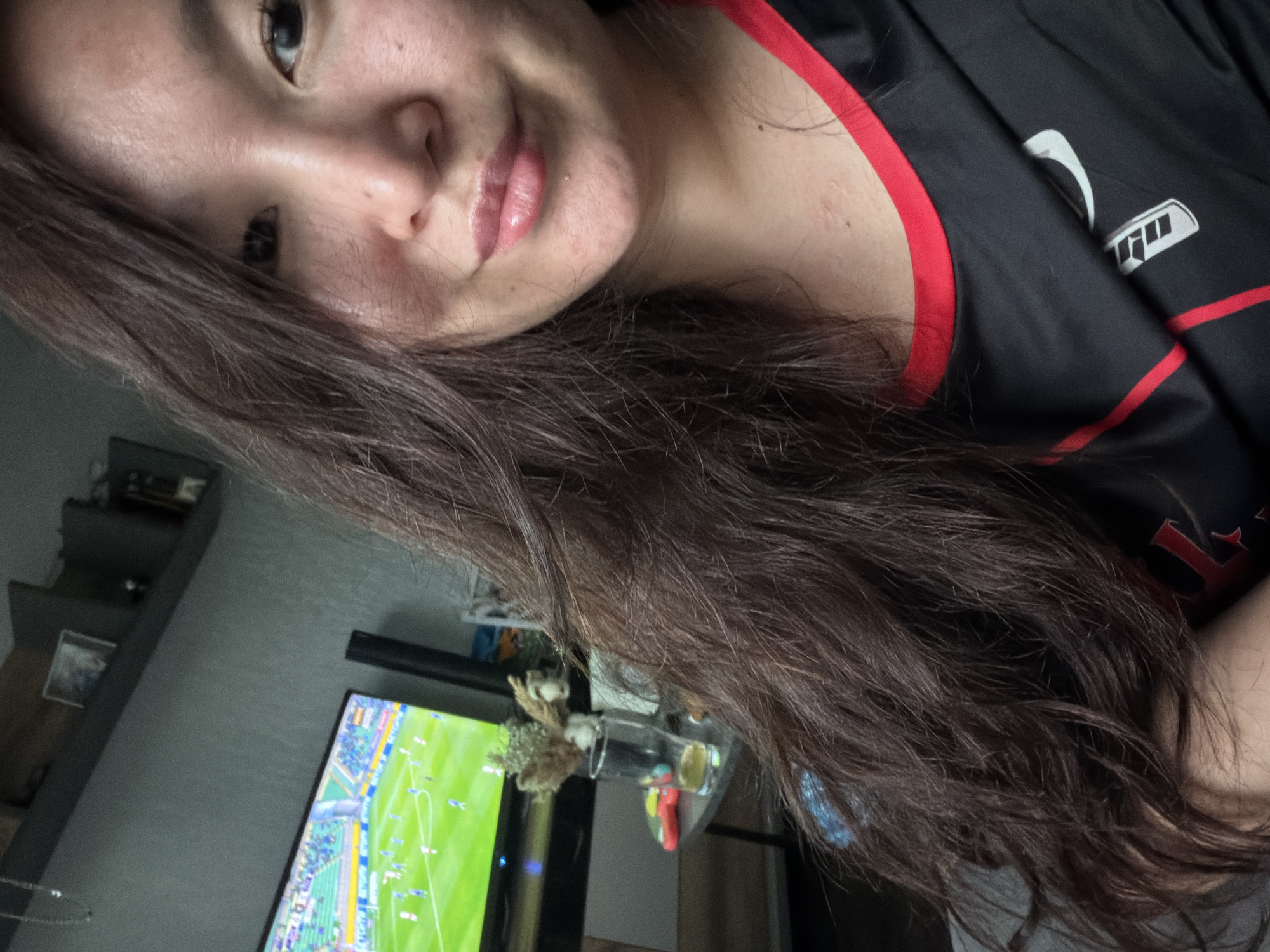 Person takes selfie while watching soccer match on television