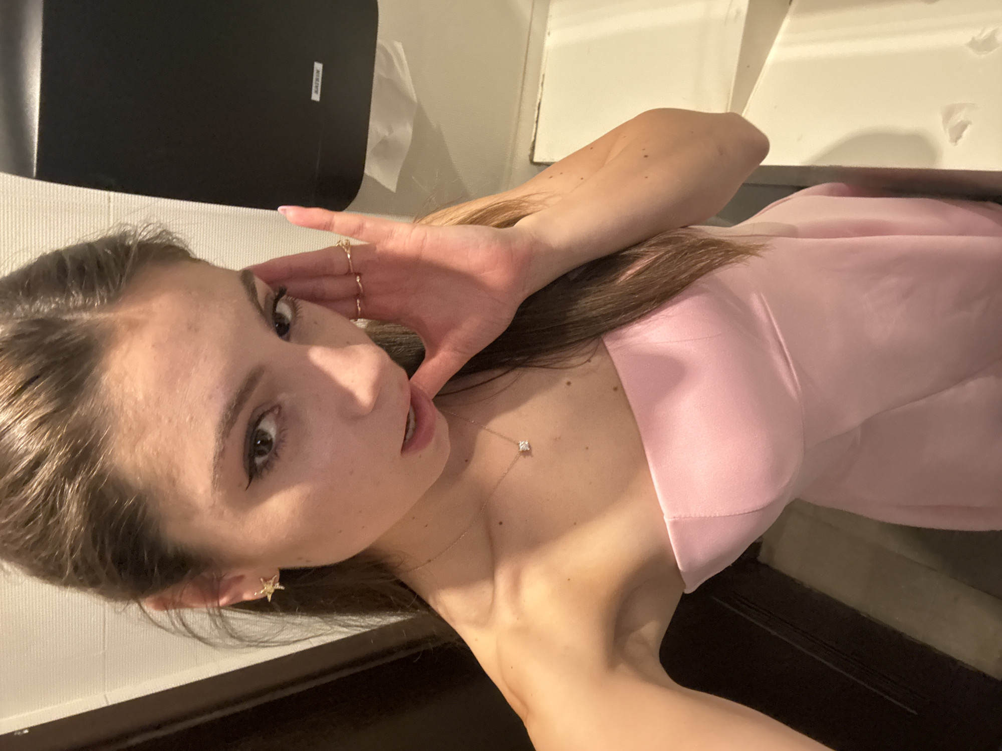 Woman takes selfie in pink dress at Shumen restroom