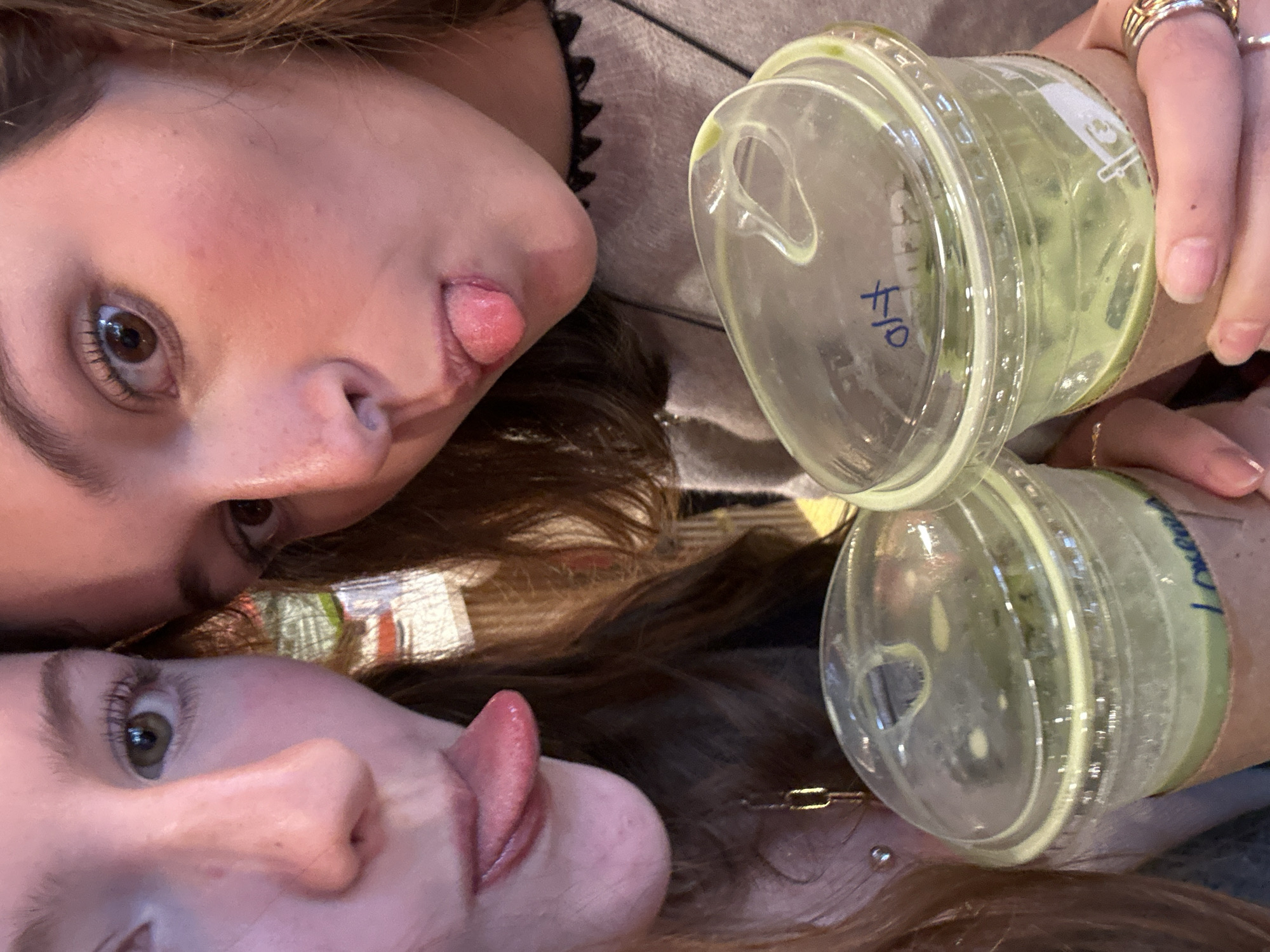 Young women socializing with drinks and taking selfies indoors