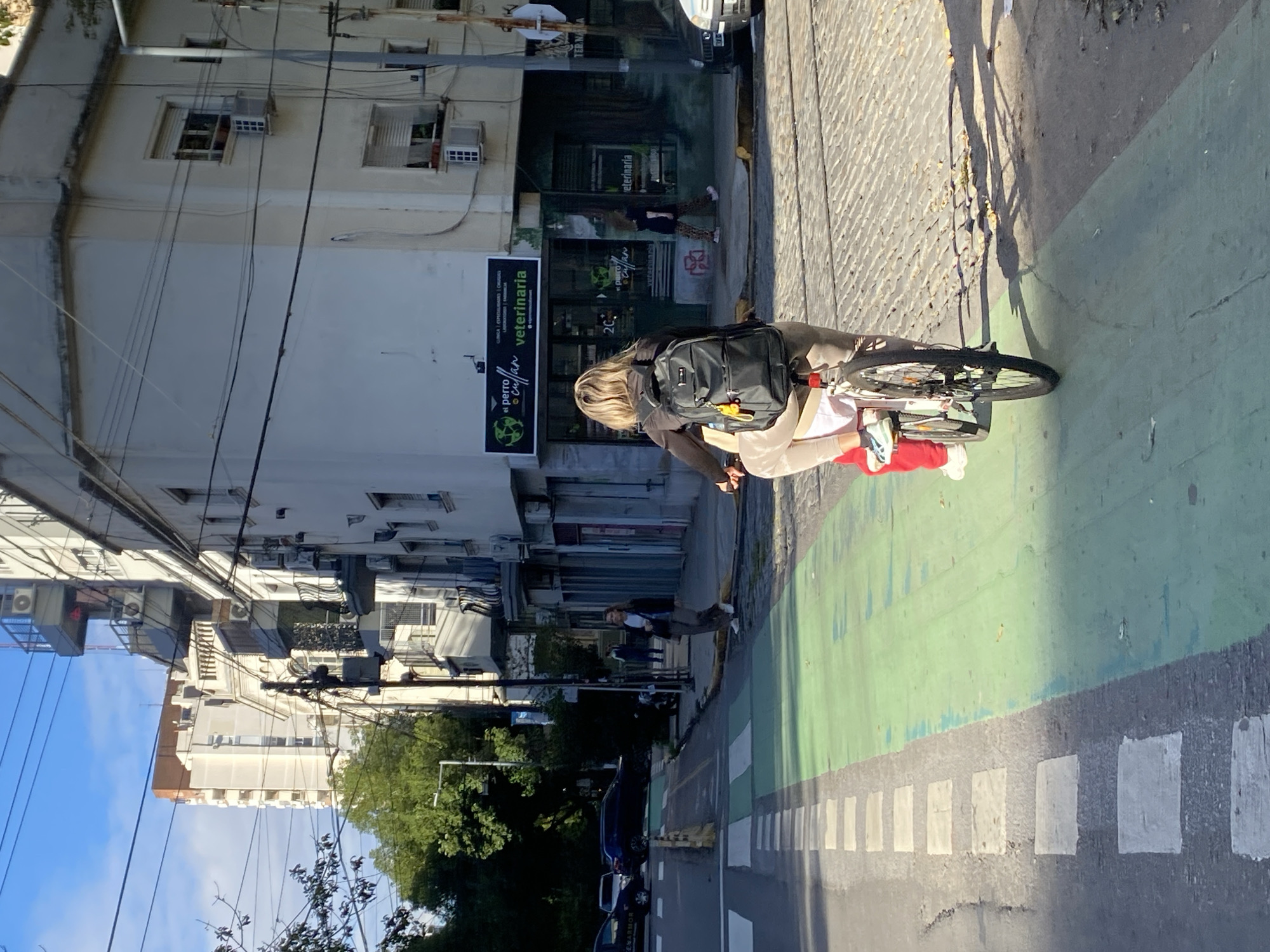 Woman cycles through Buenos Aires bike lane near veterinary clinic