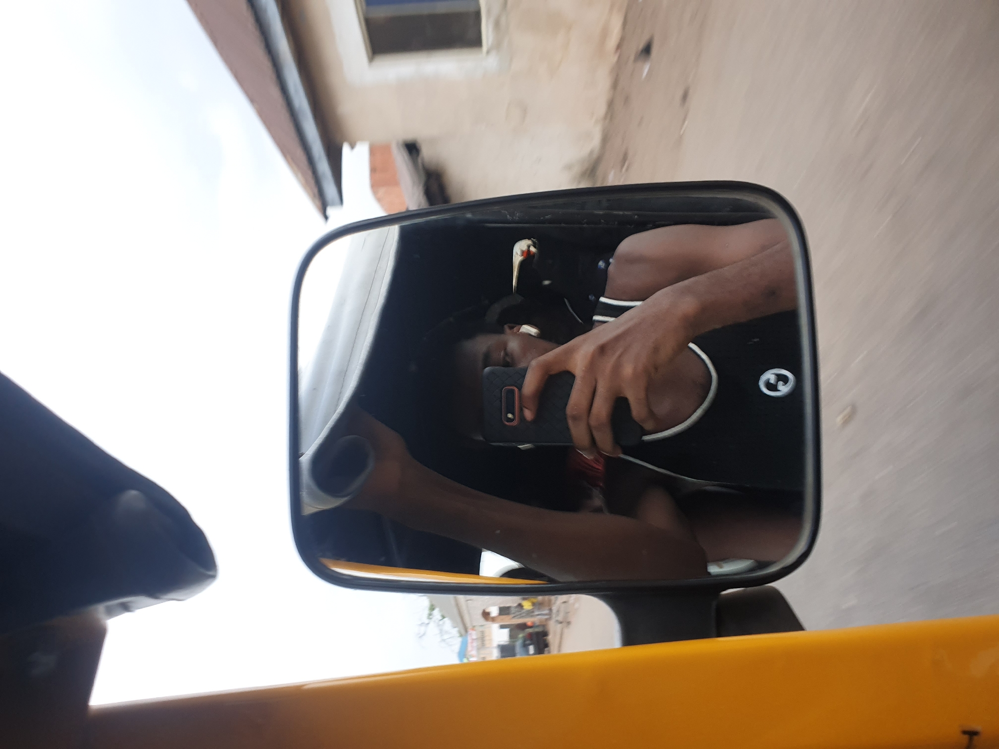 Tricycle passenger documents mirror selfies through Lokoja market streets