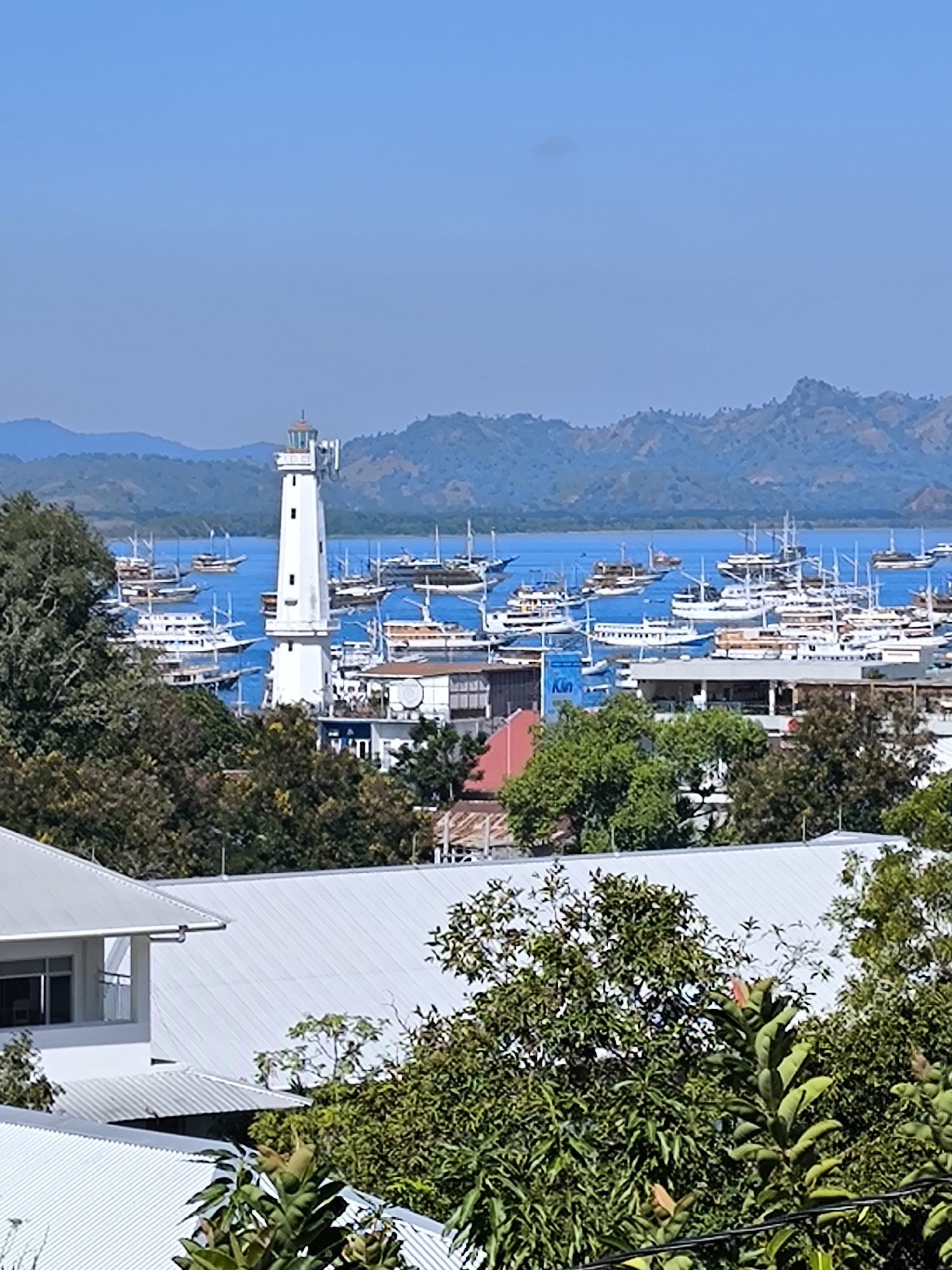 Labuan Bajo harbor and lighthouse under clear skies