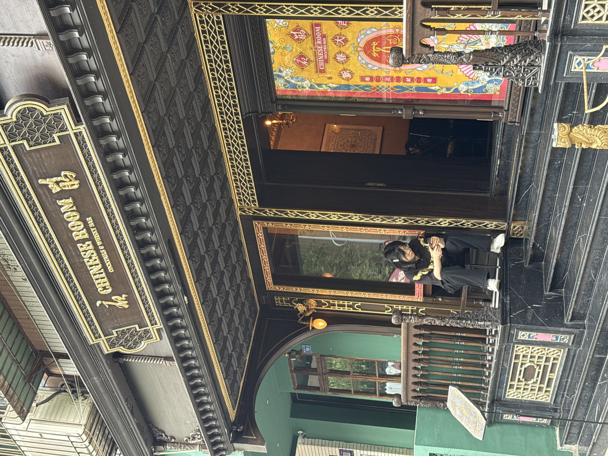 Person sits outside ornate cocktail bar in Jinjiang District