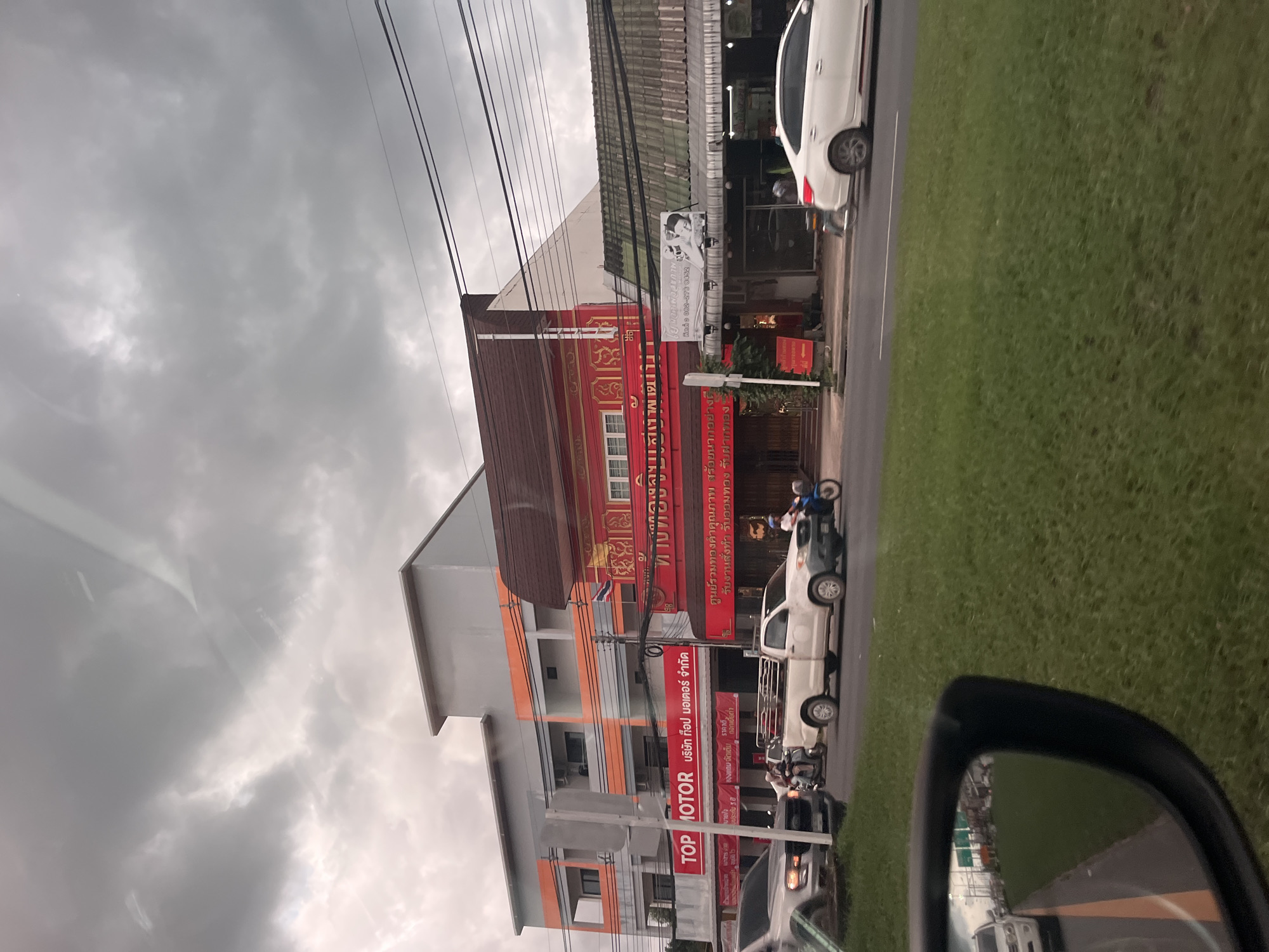 Motorist documents traffic flow in Si Sunthon under stormy skies
