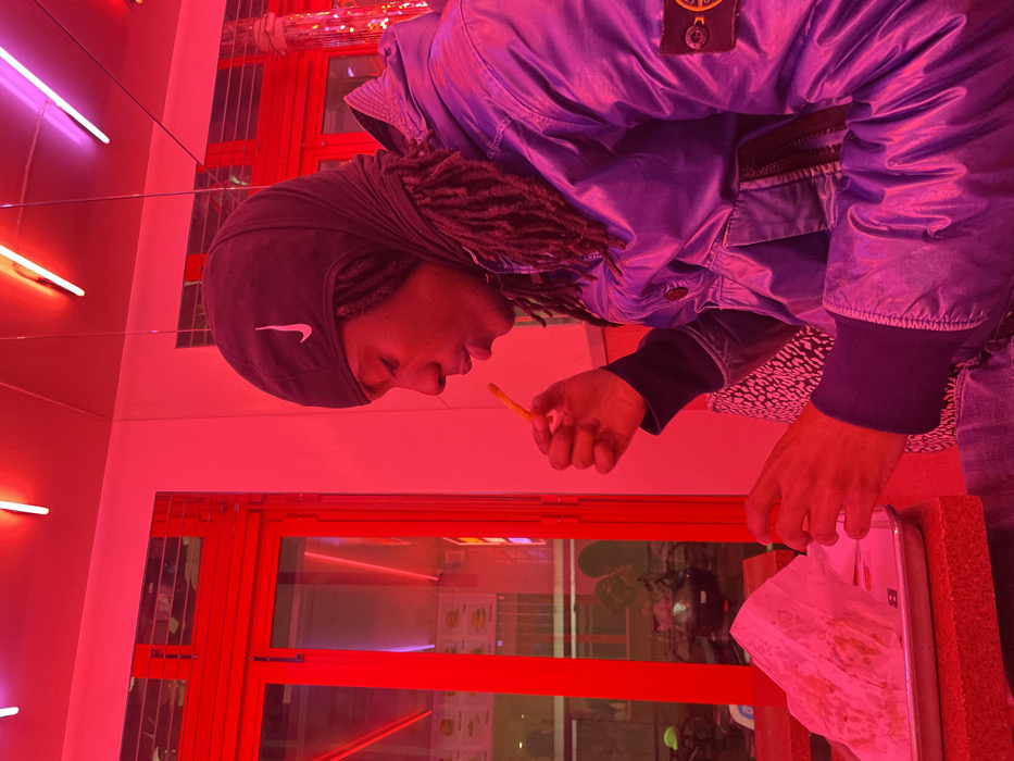 Solo diner enjoys burger meal at neon-lit Paris restaurant
