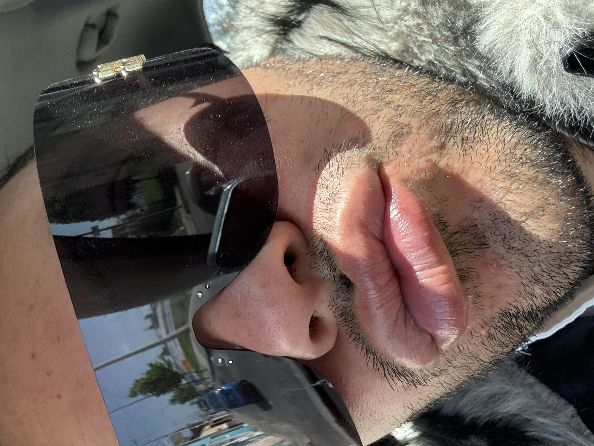 Man in sunglasses and fur jacket photographed in vehicle