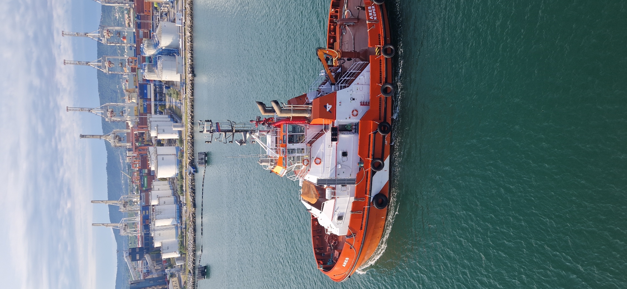 Tugboat ARES KOPER navigating Ankaran port on a clear morning