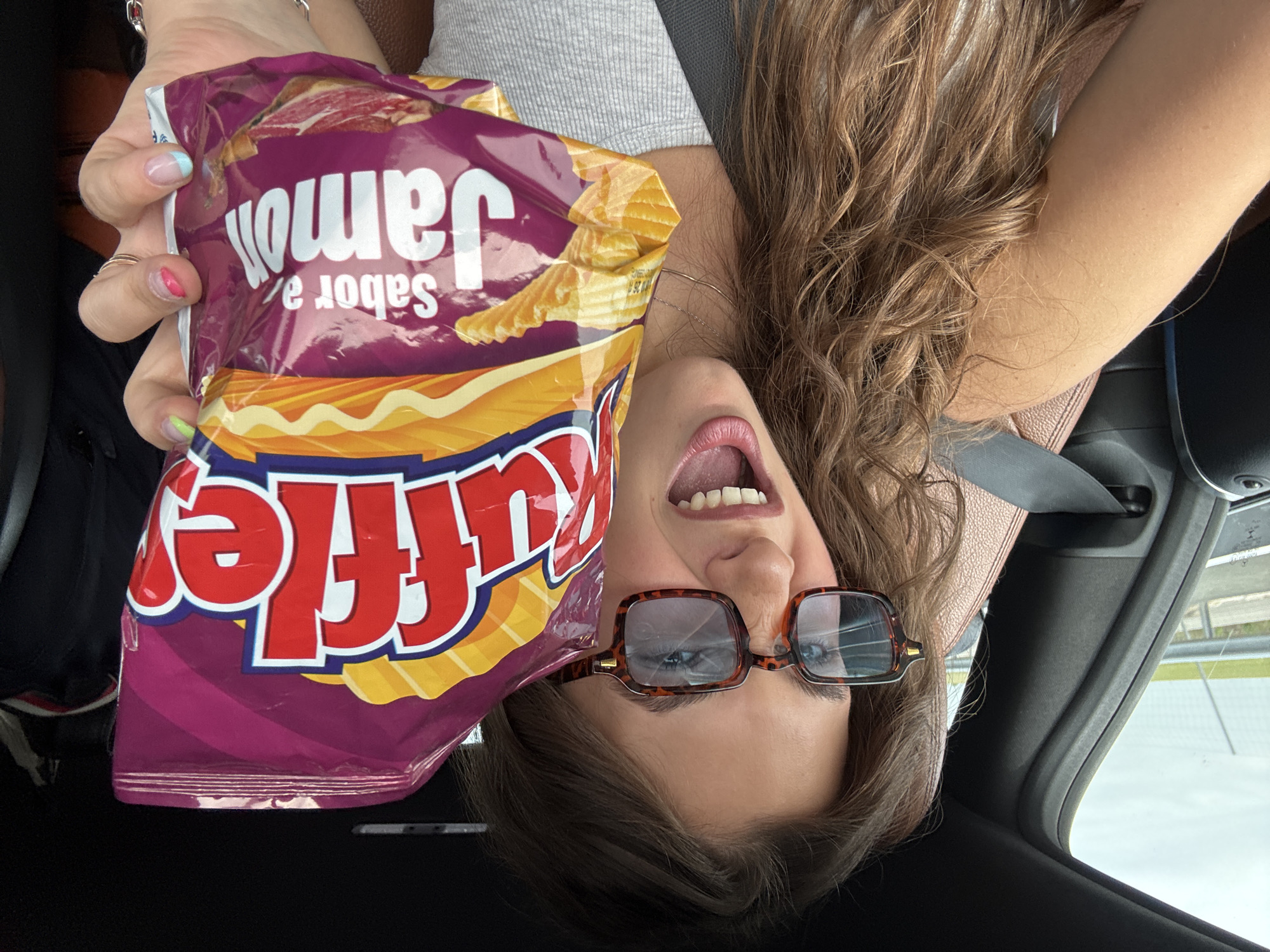 Woman poses playfully upside-down in car in Trijueque
