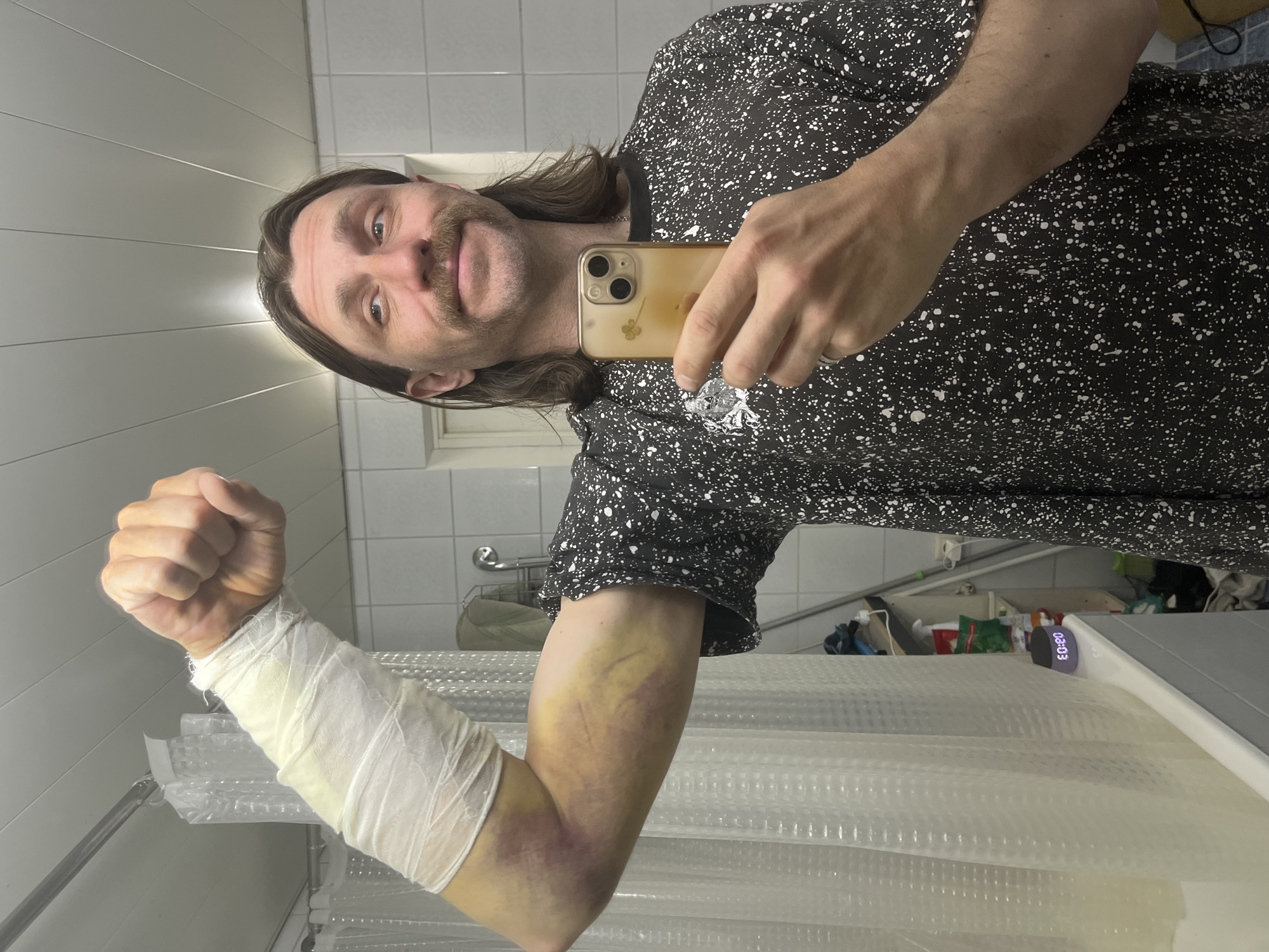 Man Takes Mirror Selfie in Bathroom Wearing Patterned Shirt
